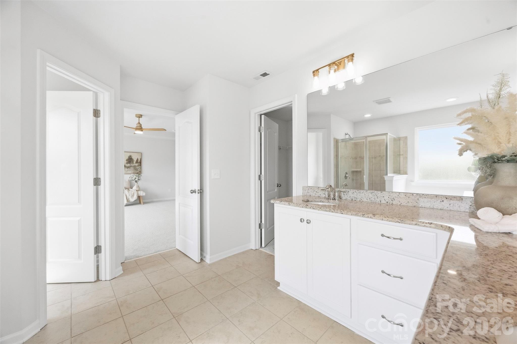 Thoughtfully designed primary bath offers abundant vanity storage and easy access to the walk-in closet and bedroom - 2015 Kensley Drive, Waxhaw