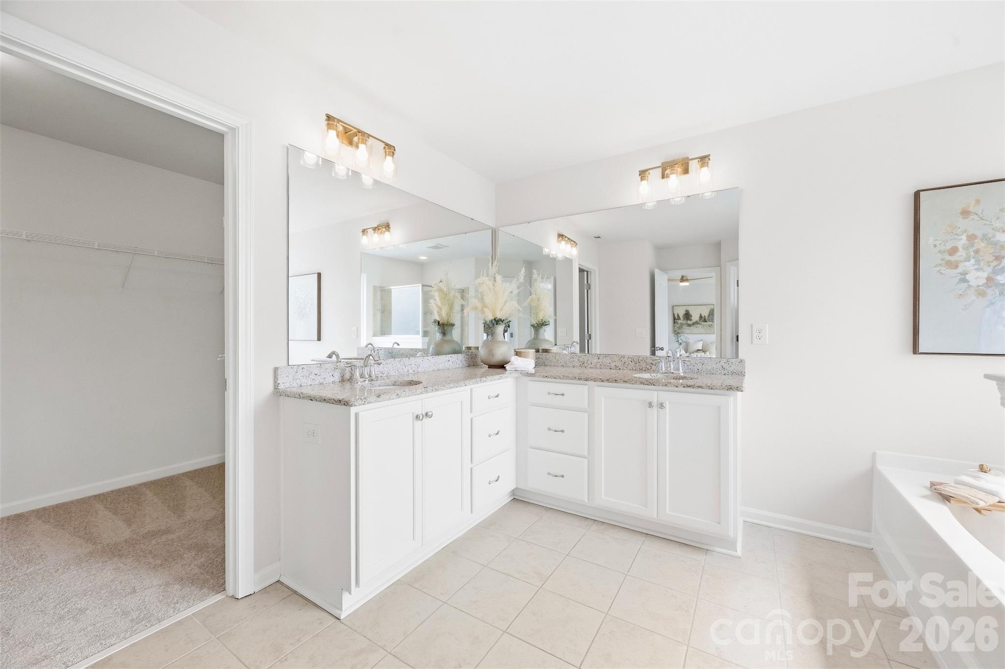 A spacious primary bath designed to impress with dual vanities, abundant storage, a soaking tub, separate shower, new lighting, and fixtures - 2015 Kensley Drive, Waxhaw