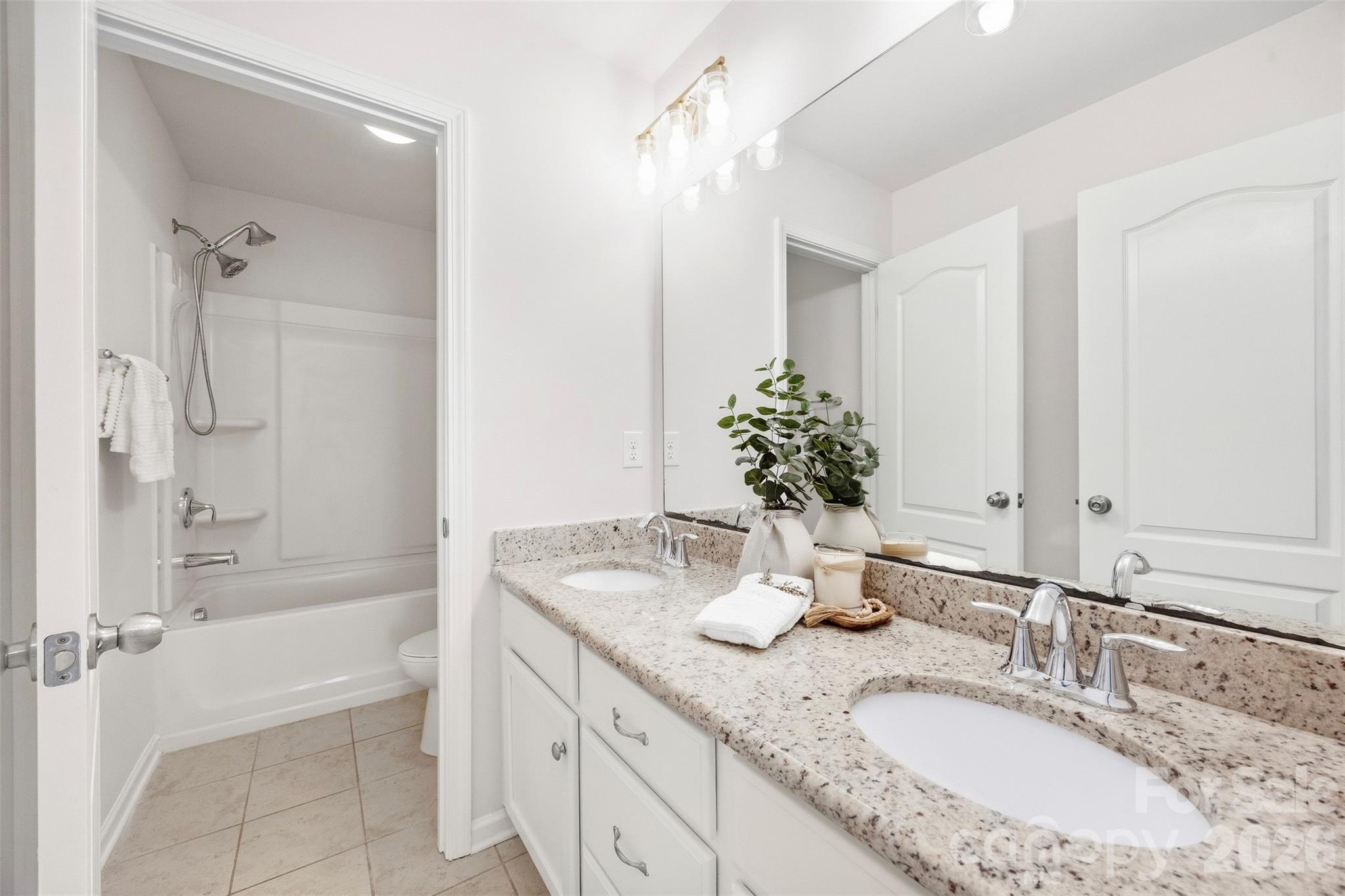 Upstairs shared full bath features a spacious dual-sink vanity - 2015 Kensley Drive, Waxhaw