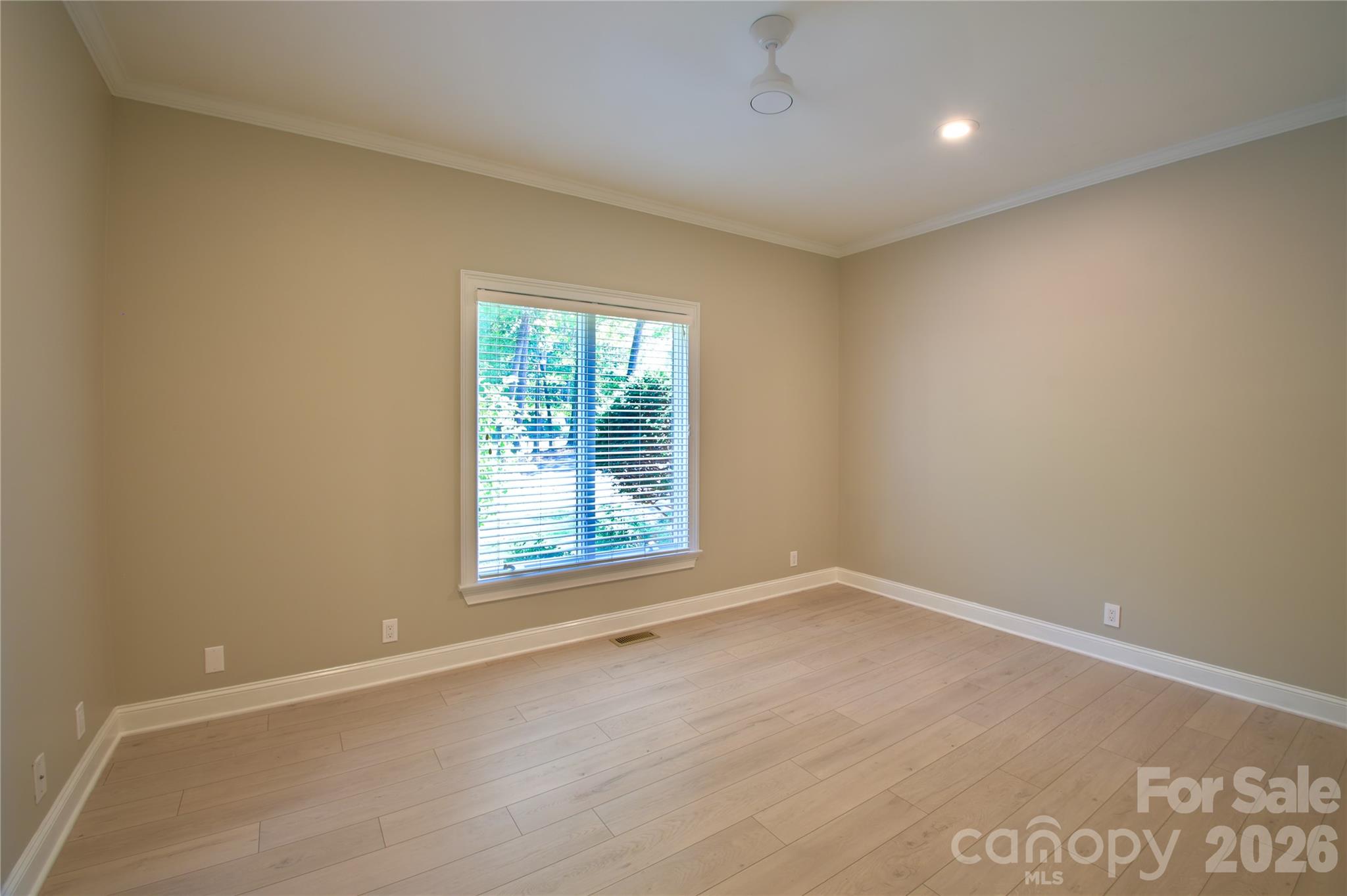 BR 1 on main floor with fresh new LVP flooring, paint, and ceiling fan. - 140 Holt Lane, Mooresville