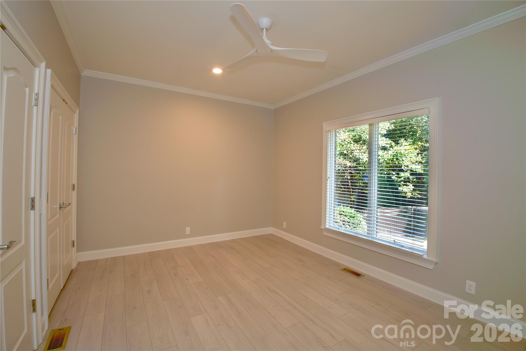 BR 2 on main floor with fresh new LVP flooring, paint, and ceiling fan. - 140 Holt Lane, Mooresville