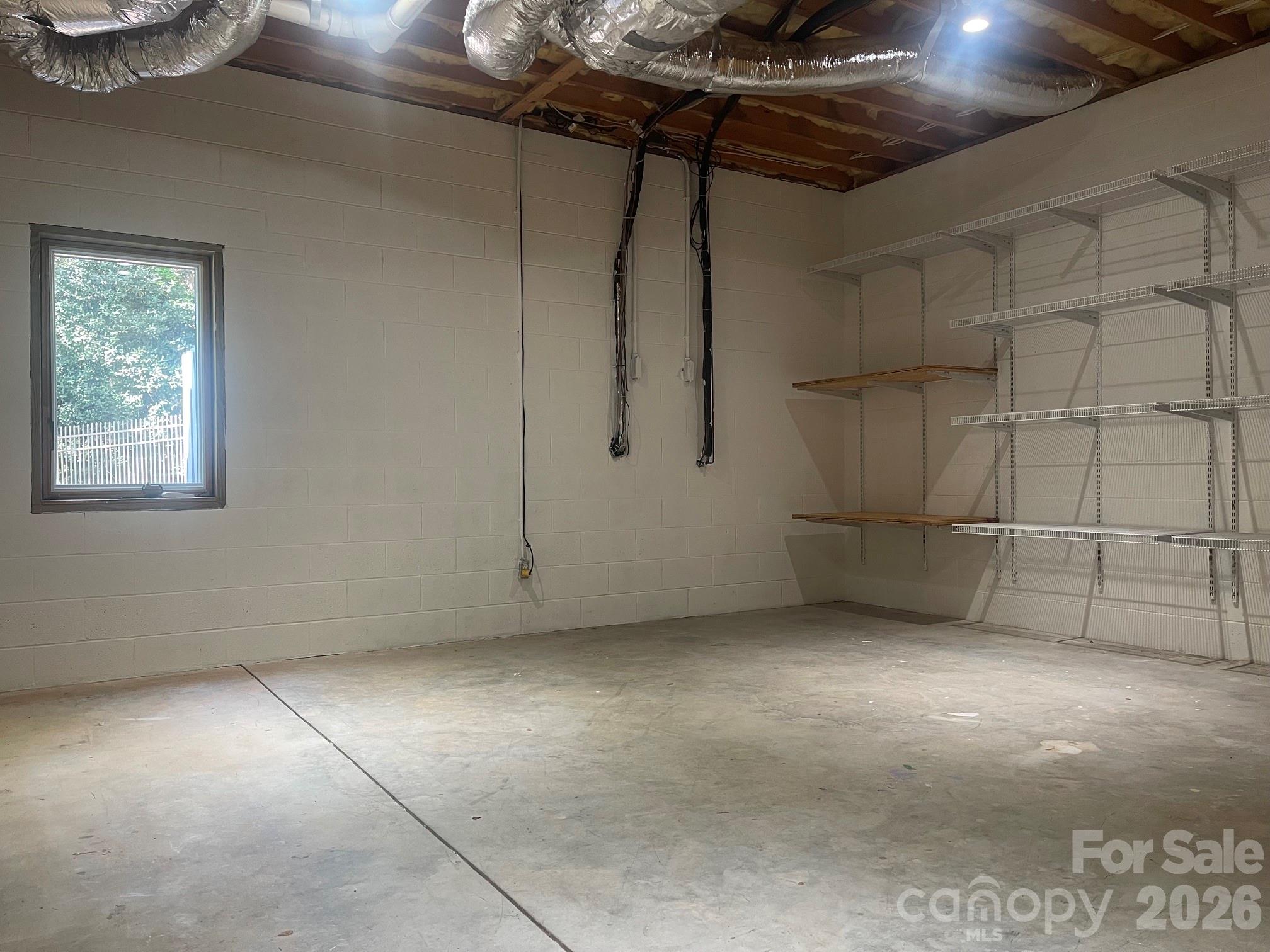 This is a huge unfinished workshop/storage that has a window if someone wanted to turn it into a finished area. There is also the mechanical room and a "tornado" room in the basement for even more storage options! - 140 Holt Lane, Mooresville
