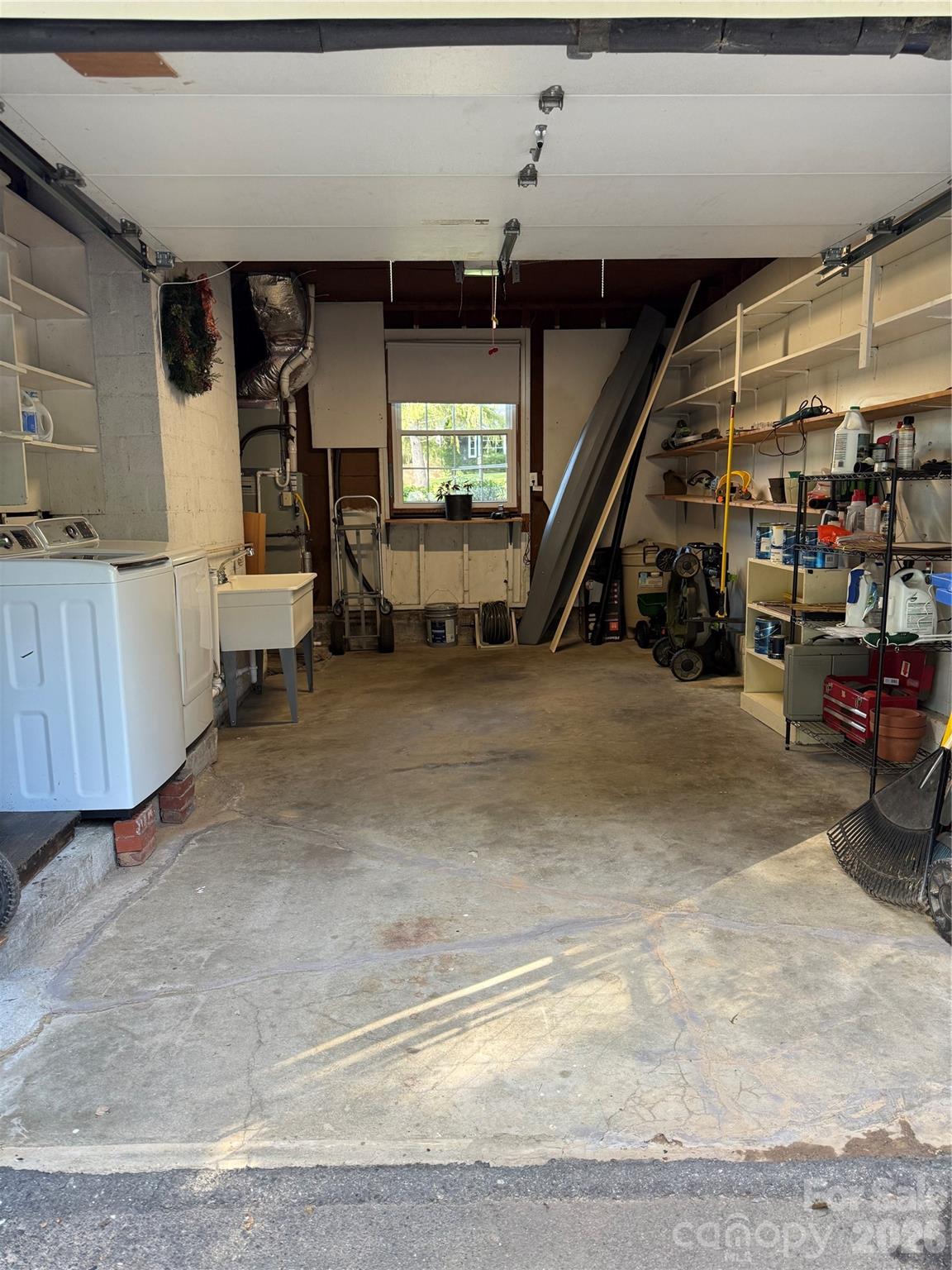 Attached single car garage with lots of storage space, laundry area (washer/dryer) and large utility sink. - 111 Gracelyn Road, Asheville