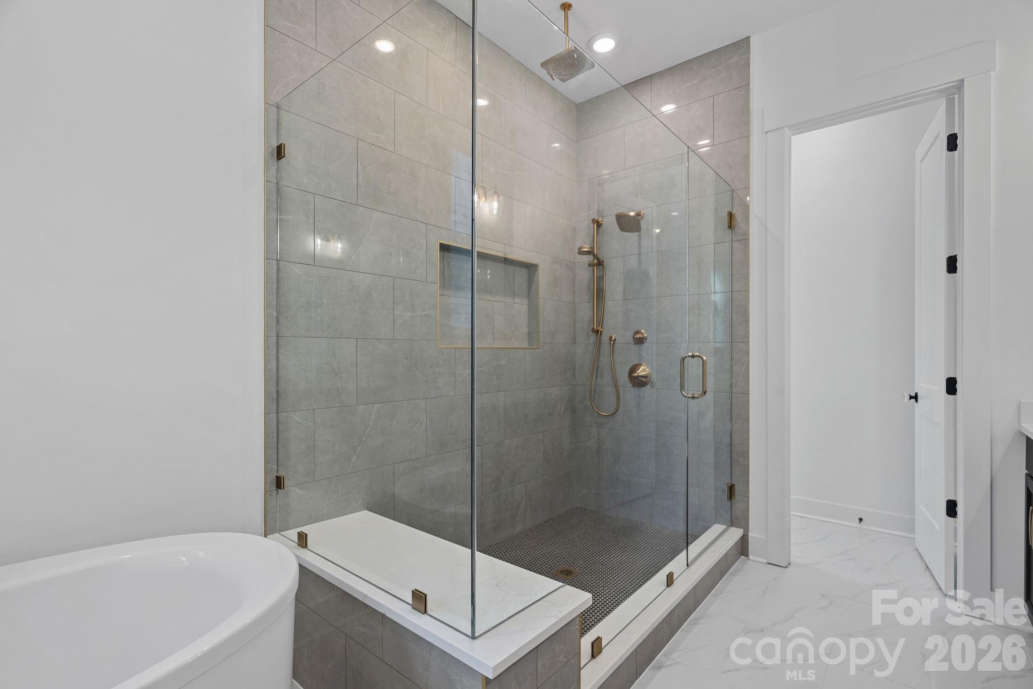 Primary ensuite with soaking tub, walk-in shower with rainshower heads and handled; large walk-in closet with built-ins. - 4477 Splash Trail, Sherrills Ford