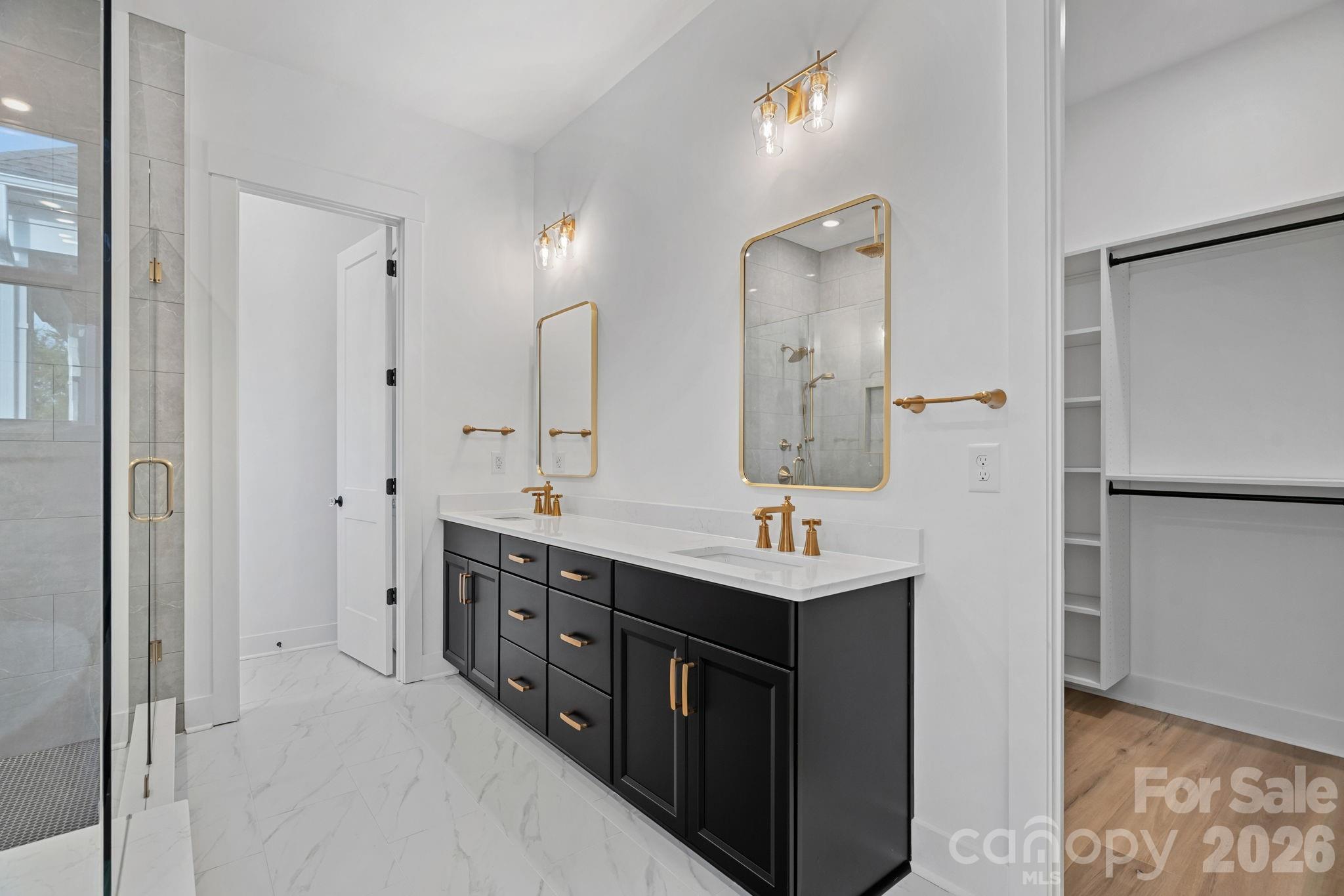 Primary ensuite with soaking tub, walk-in shower with rainshower heads and handled; large walk-in closet with built-ins. - 4477 Splash Trail, Sherrills Ford