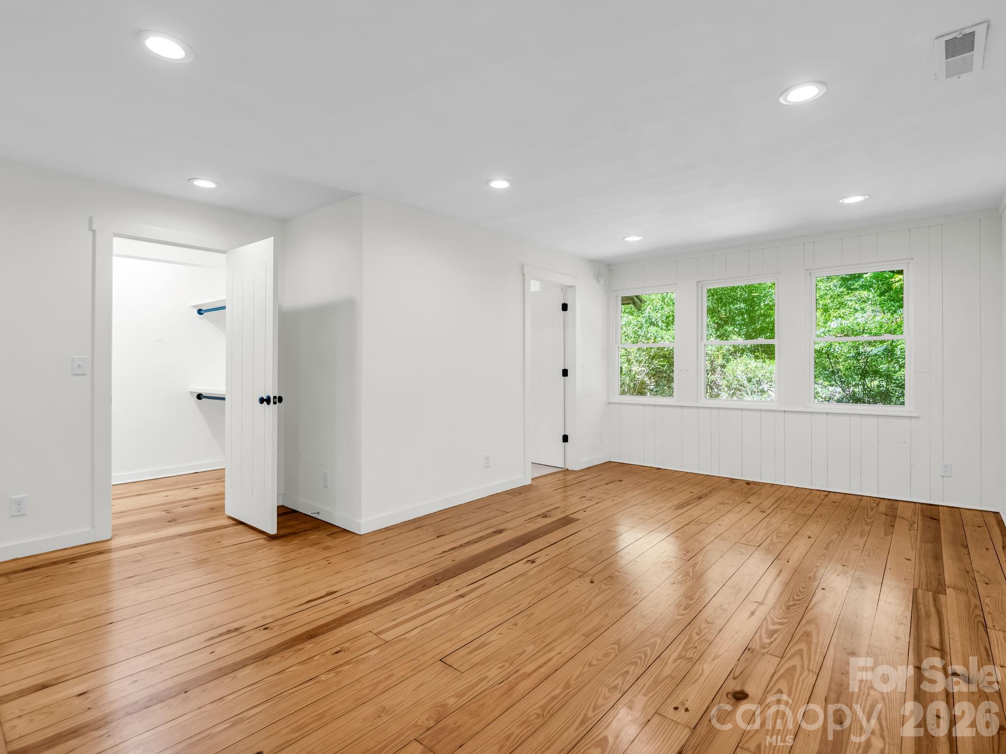 Primary bedroom with walk-in closet and en-suite tile bathroom - 145 Stone Hedge Lane, Tryon