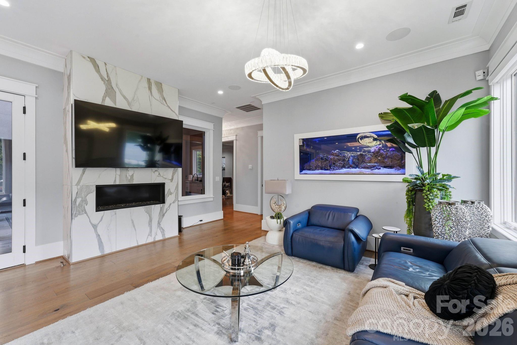 Living Room with High End Quartz Fireplace and Salt Water Aquarium - 15700 Youngblood Road, Charlotte