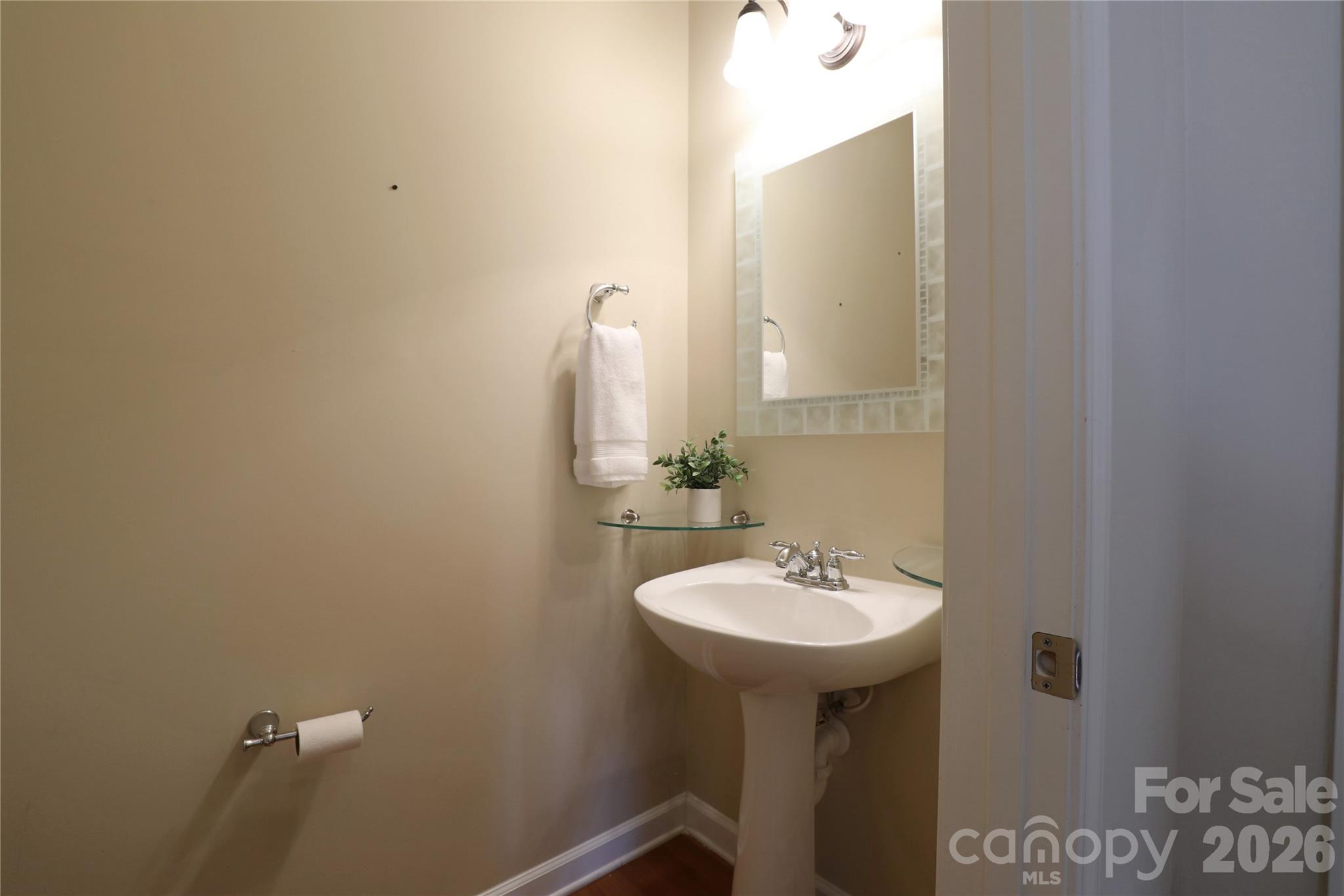 Half bath on main level conveniently tucked near laundry and garage access. - 18465 E Marbella Lane, Fort Mill