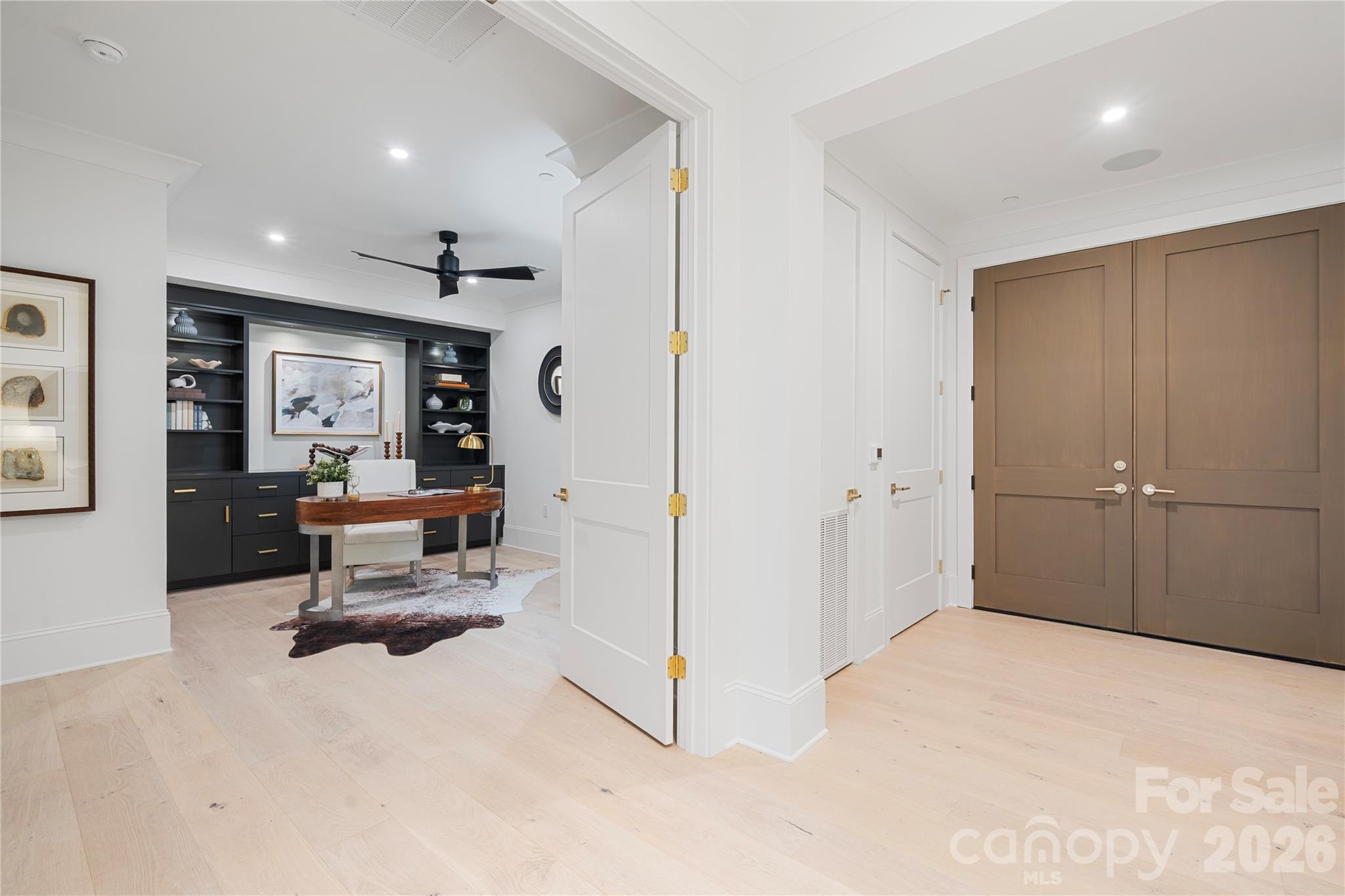 Just off the entry, the sophisticated office with custom cabinetry provides views across the Great Room and beyond, or can be closed-off for maximum privacy. - 409 Queens Road, Charlotte