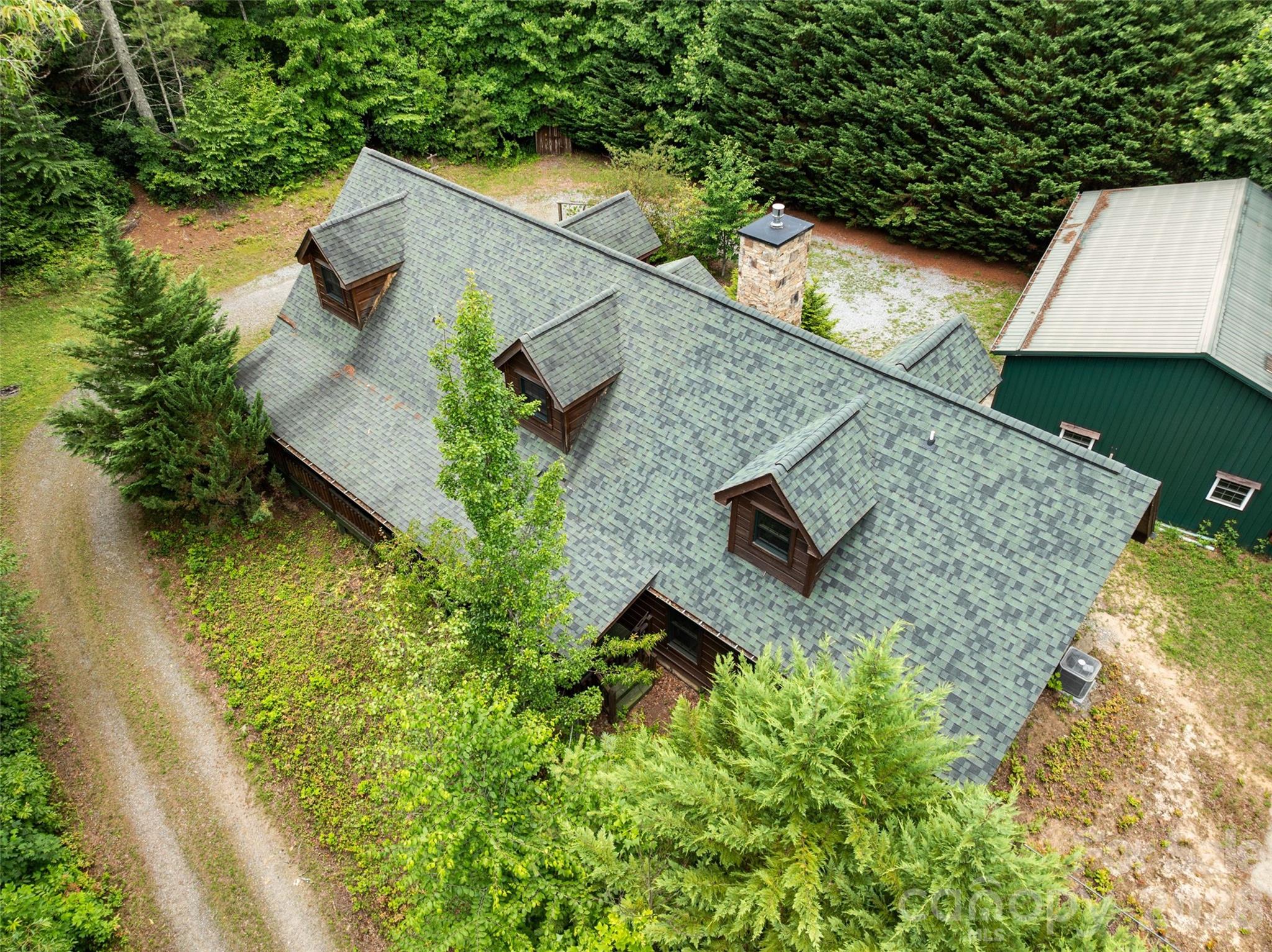 Bird's-eye view showing the wrap-around driveway and massive detached shop building. - 213 Big Valley Road, Pisgah Forest