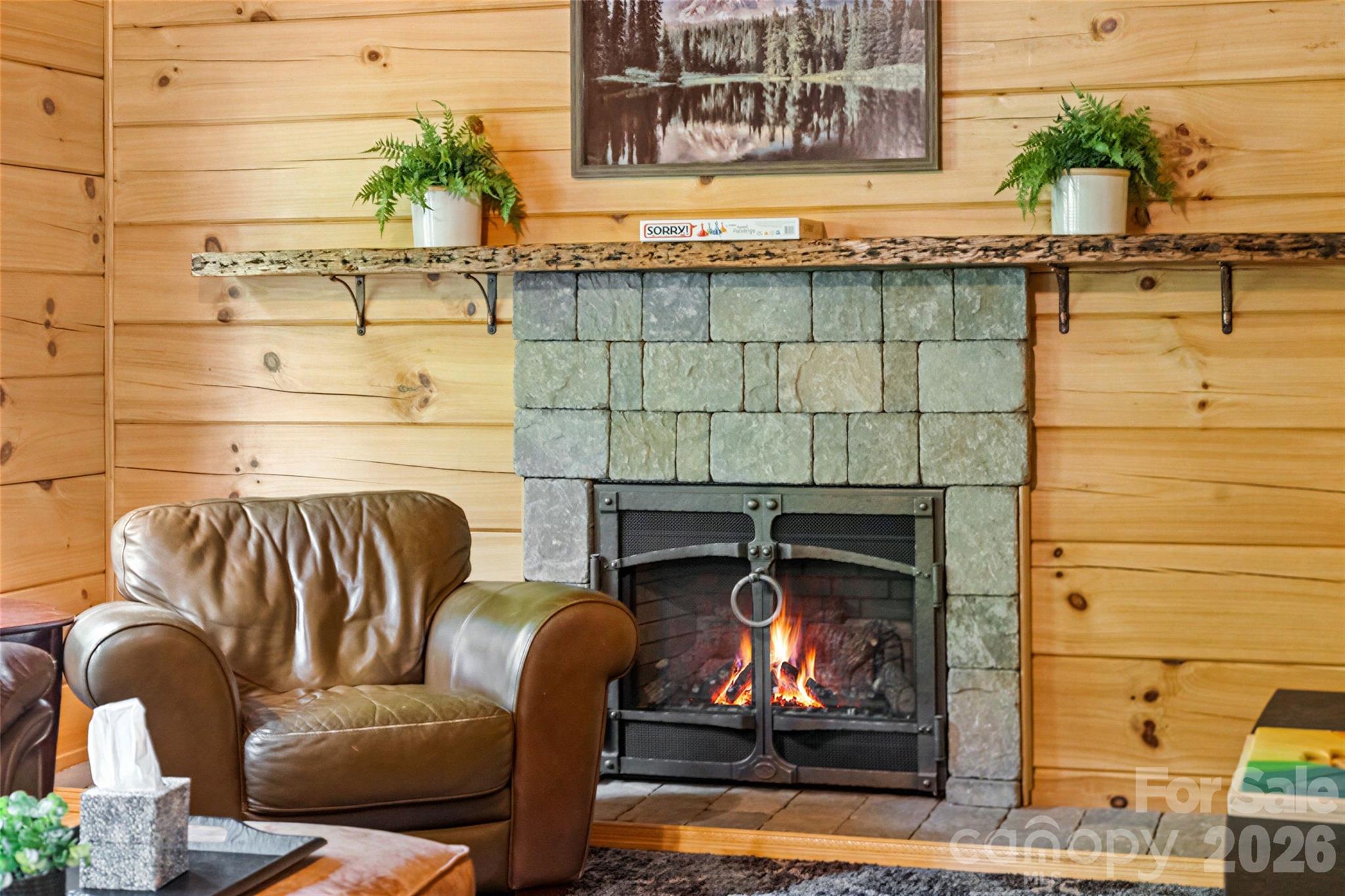 Rustic living space centered around a custom wood mantel and hearth. - 213 Big Valley Road, Pisgah Forest