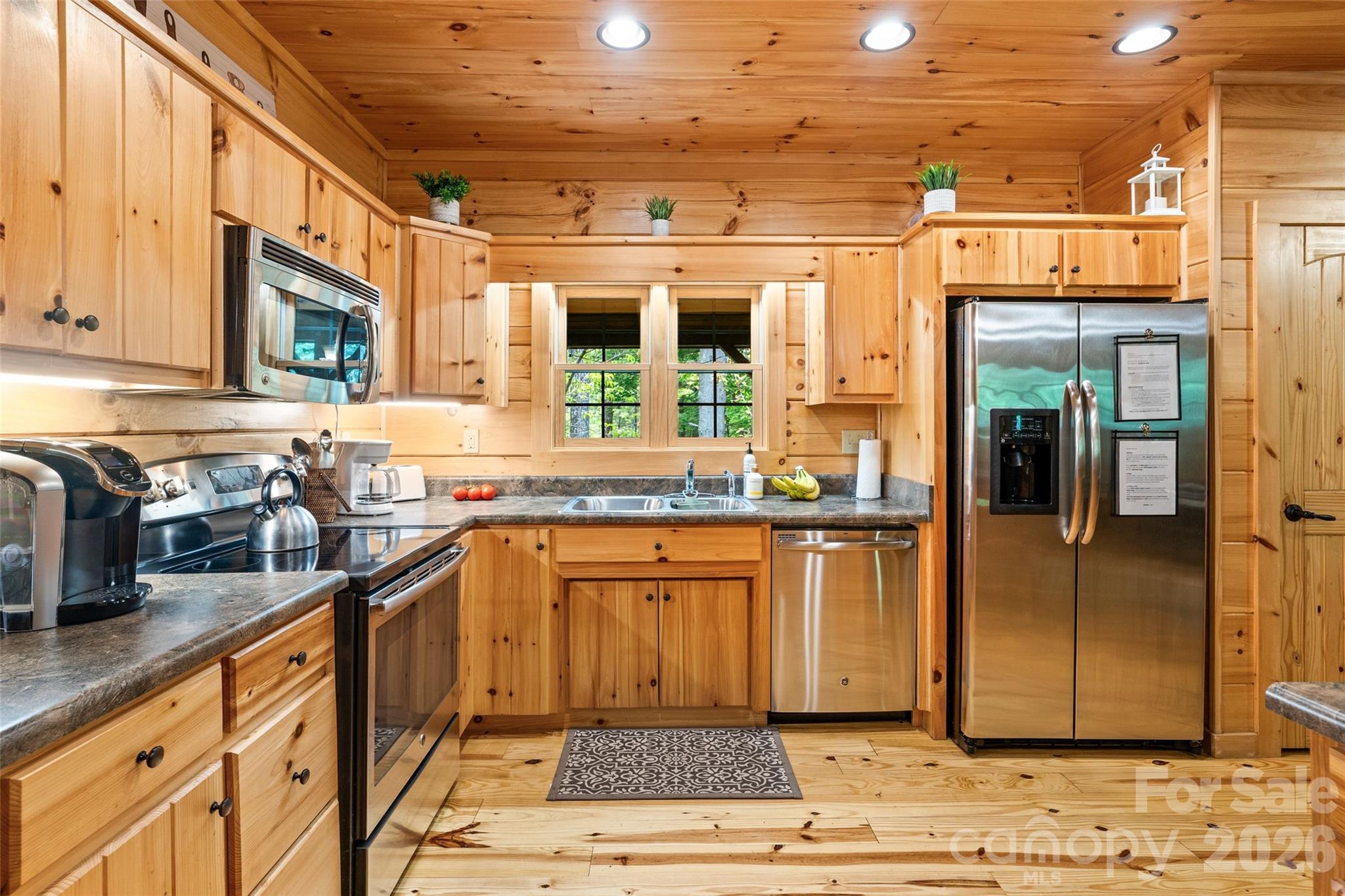 Beautifully appointed rustic kitchen with glowing pine cabinetry. - 213 Big Valley Road, Pisgah Forest
