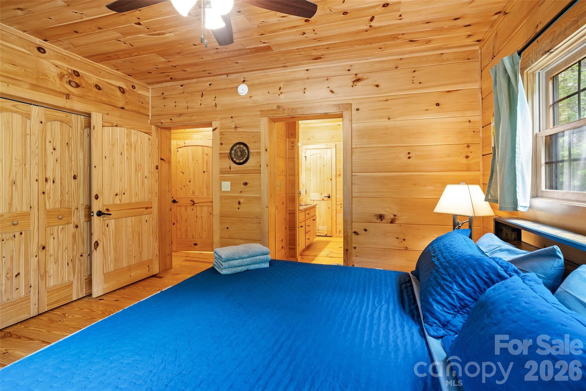 Spacious primary bedroom featuring direct access to an en-suite bathroom. - 213 Big Valley Road, Pisgah Forest
