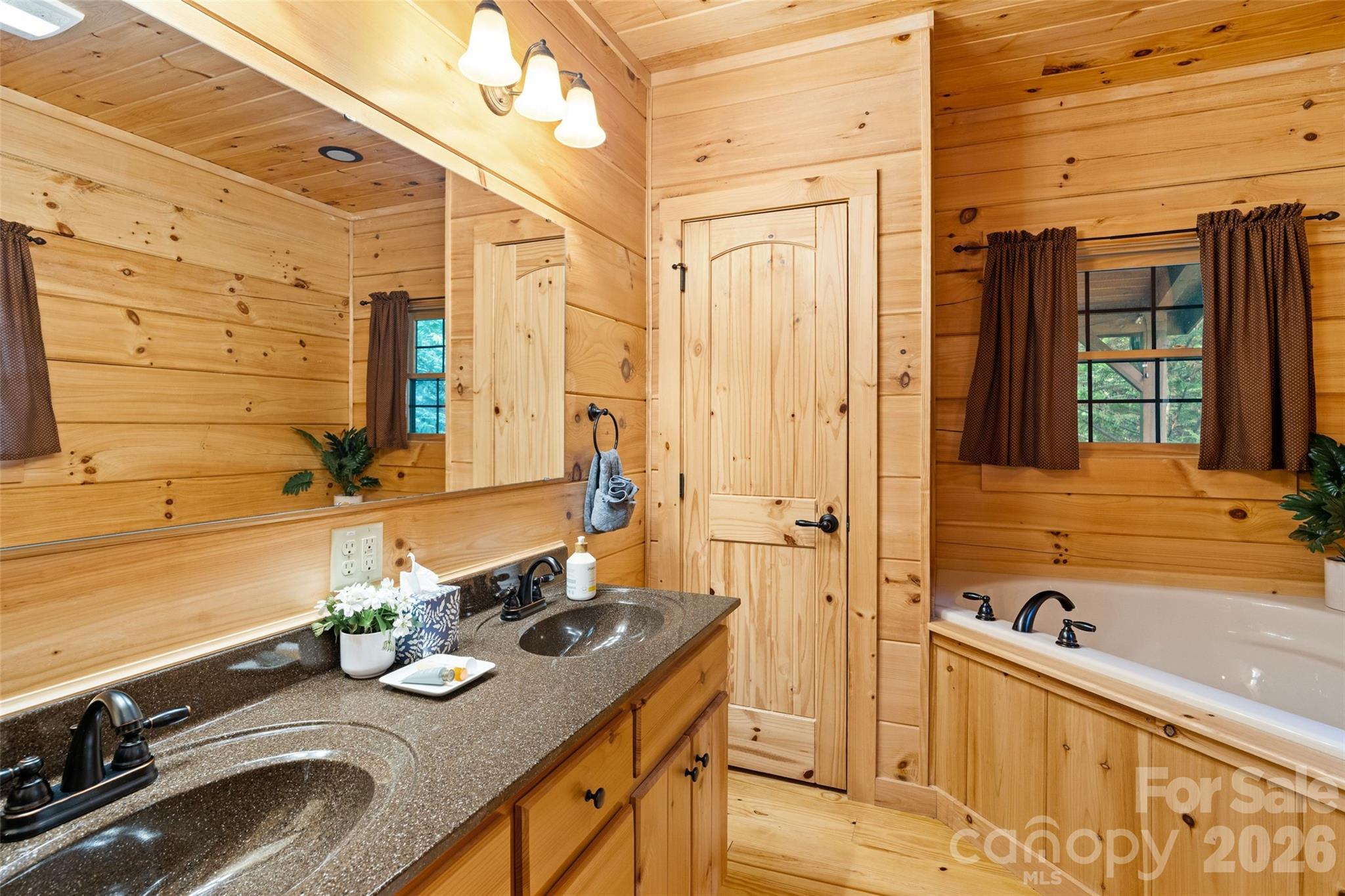Primary en-suite bath with double vanity and deep soaking tub. - 213 Big Valley Road, Pisgah Forest