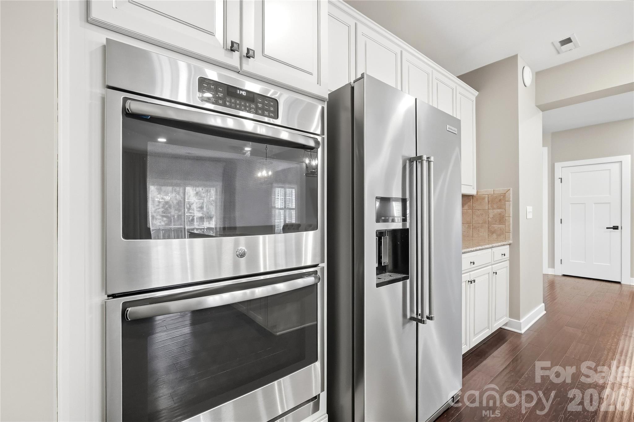 Stainless appliances, including a GE double wall oven and a KitchenAid side-by-side refrigerator (purchased 2024). - 912 Manorwood Drive, Waxhaw
