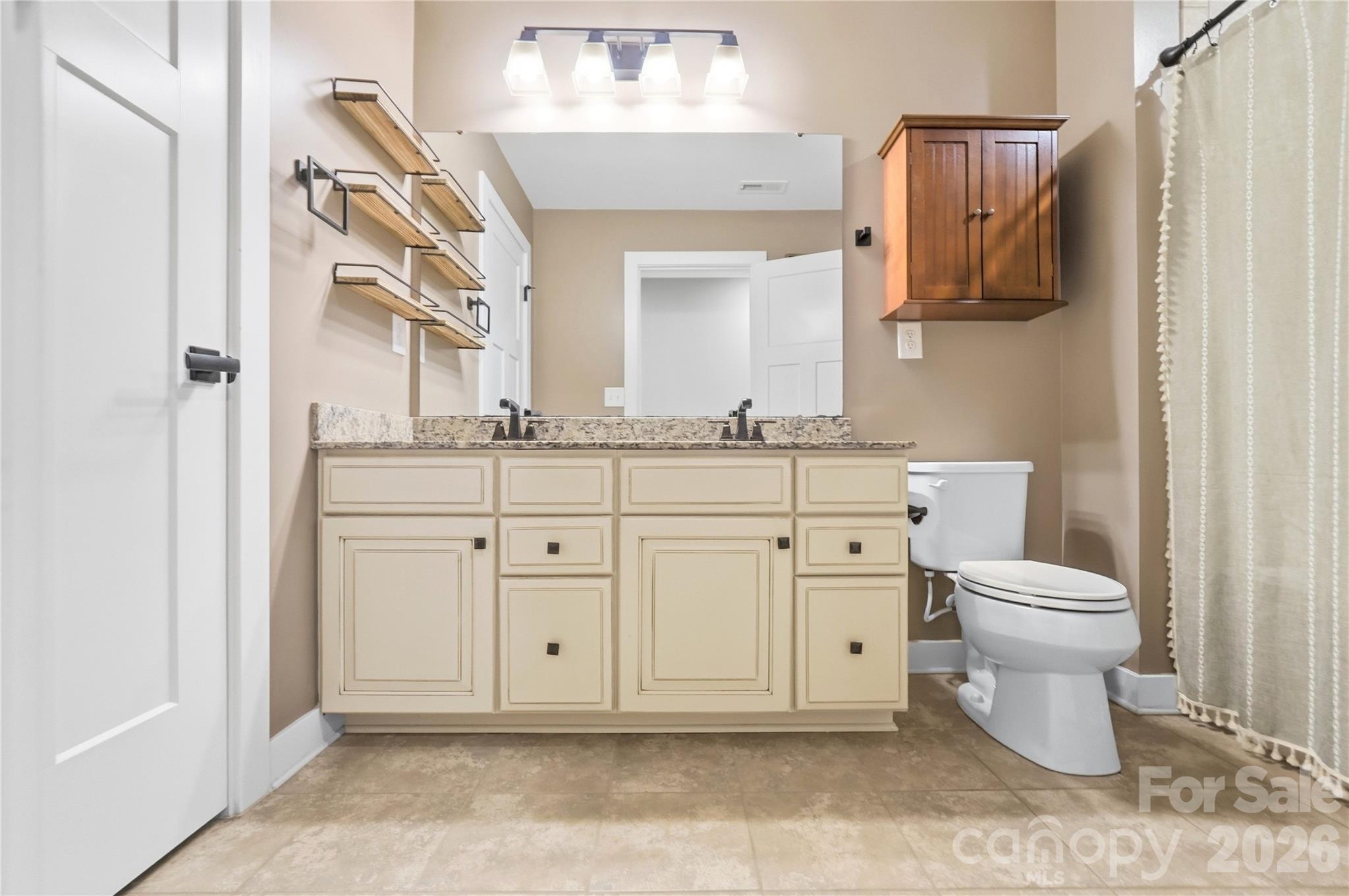 Hall bath with a dual-sink granite vanity, tile flooring, and a tub/shower combination. - 912 Manorwood Drive, Waxhaw