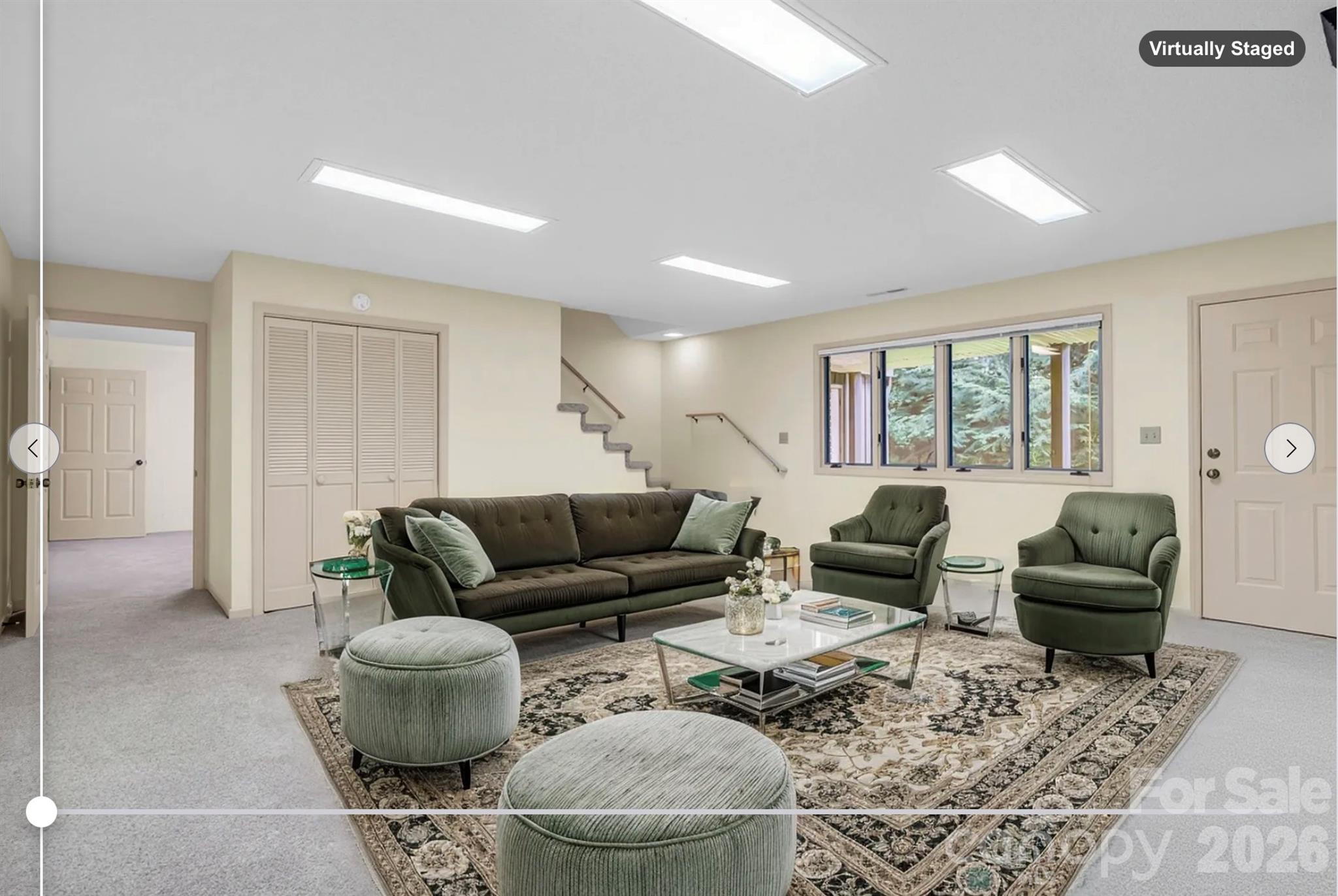 virtually staged/alternate style - Lower Level family room w/ wood burning fireplace, door leads to fenced backyard - 115 Woodhaven Drive, Hendersonville