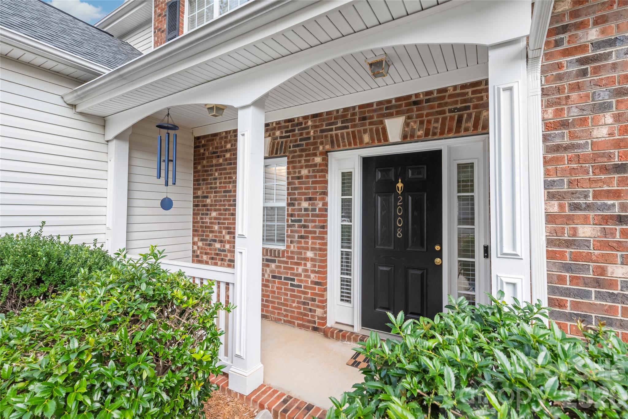 Framed by elegant sidelights, the inviting front door floods the entryway with natural light, offering a warm and bright welcome. - 2008 Trace Creek Drive, Waxhaw