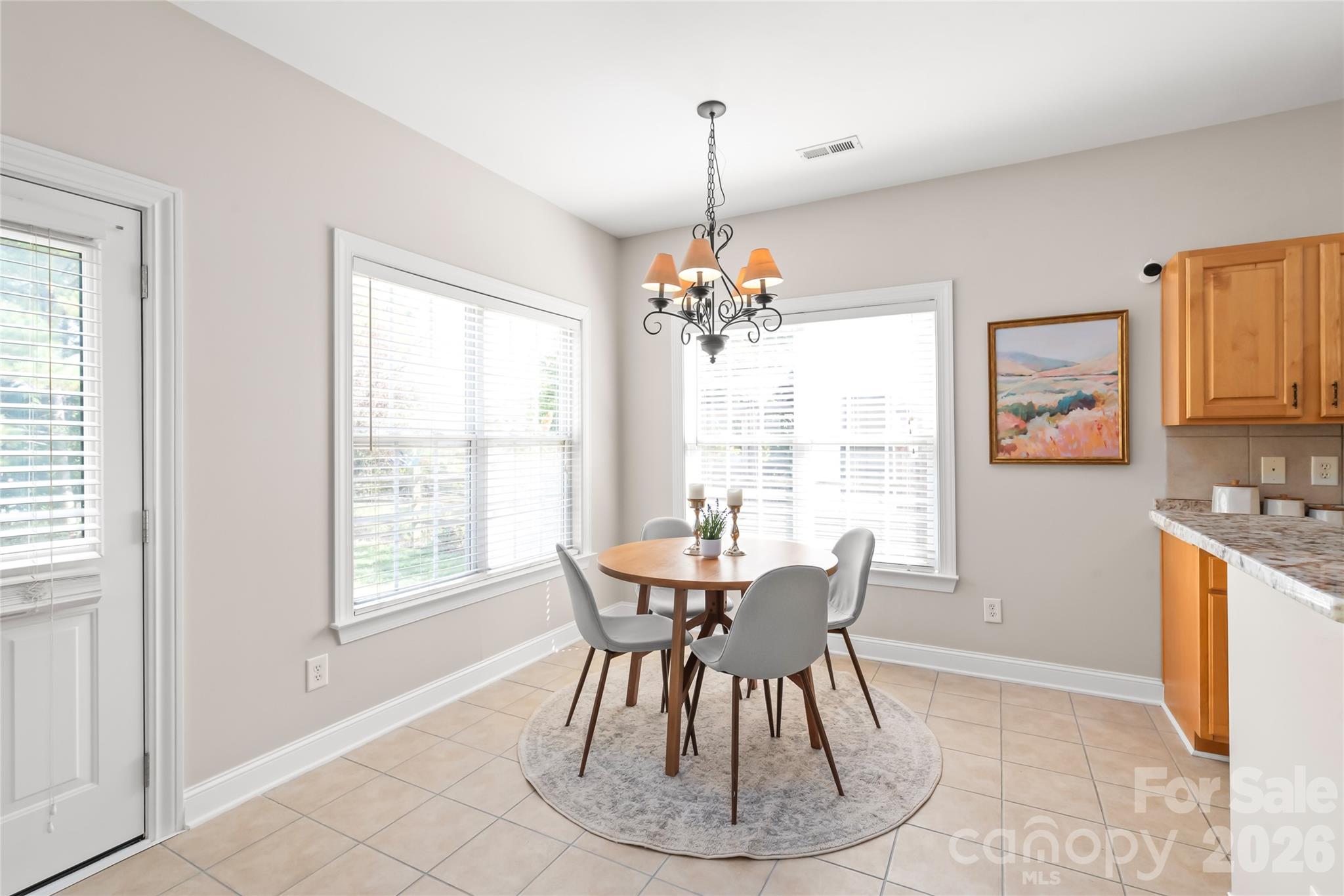Start your morning in the bright breakfast nook, featuring direct access to the back patio through a durable, fire-resistant door that seamlessly connects your kitchen to the private, wooded backyard. - 2008 Trace Creek Drive, Waxhaw