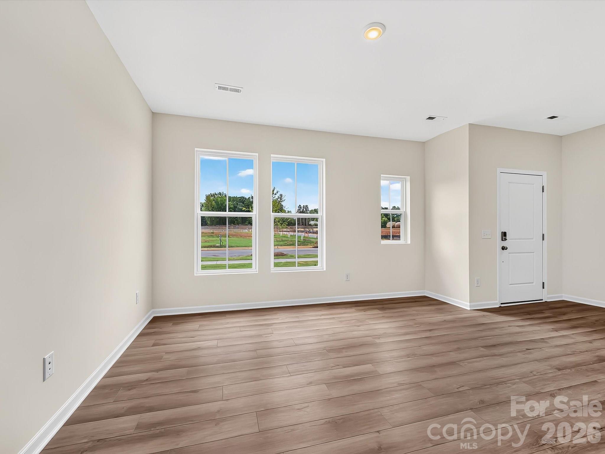 Open Layout of Family Room on 1st Floor with Kitchen and Dining Area - 6565 Fire Lily Lane, Charlotte