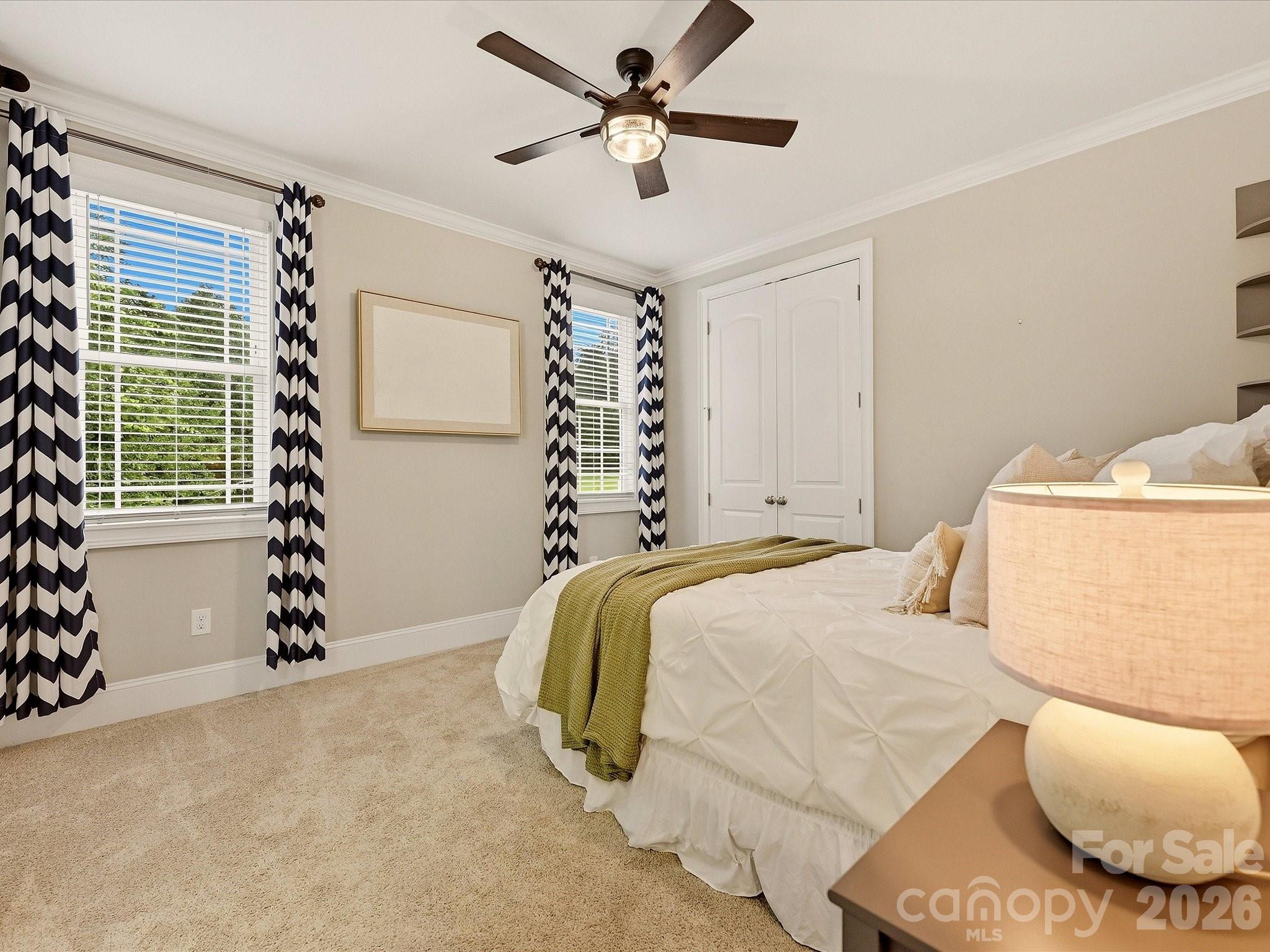 Bedroom 2 offers generous space, soft carpeting, crown molding, abundant natural light, a ceiling fan, and convenient access to a full bath. - 3167 James Plantation Drive, Denver