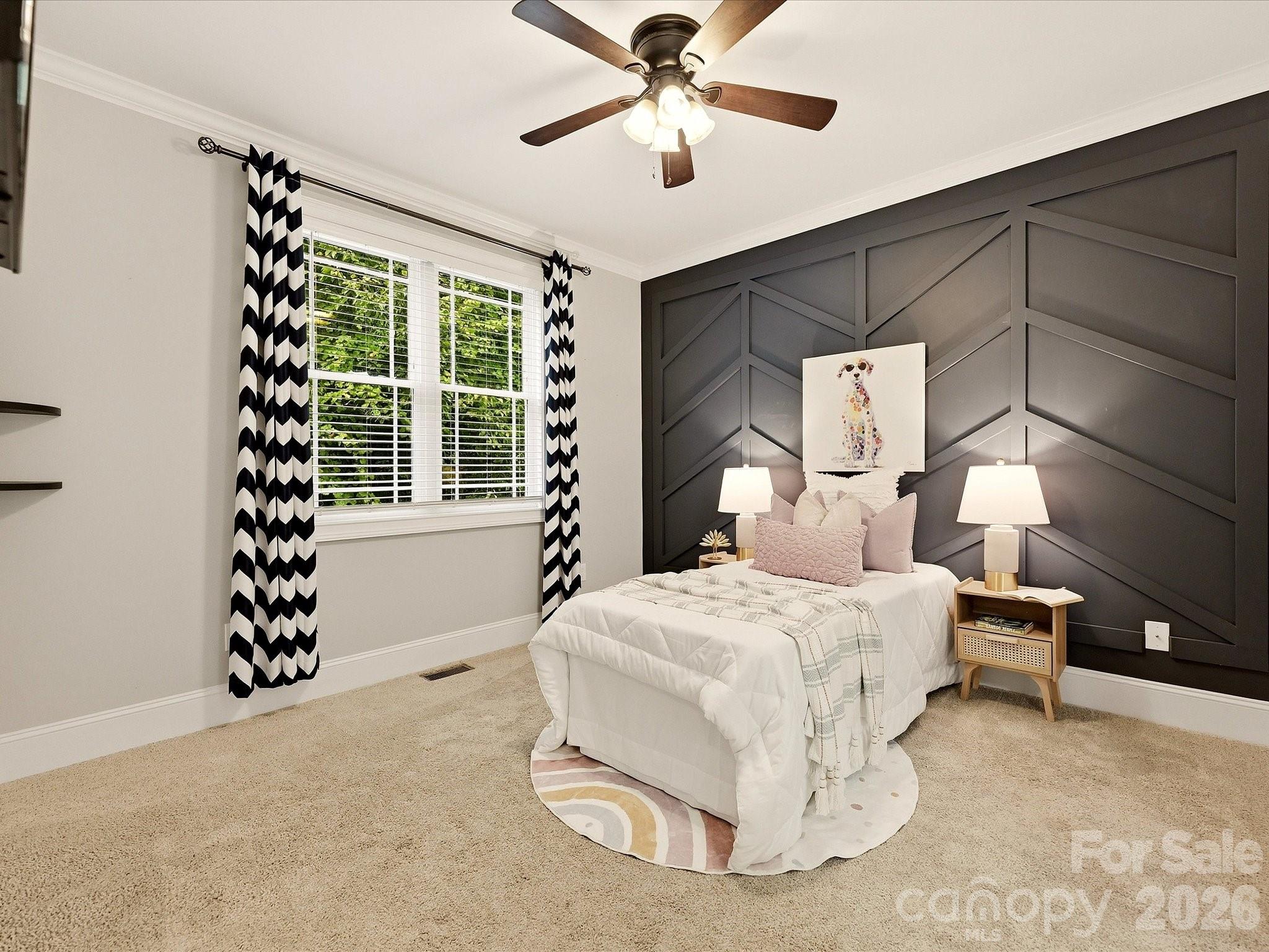 Bedroom 3 offers generous space, soft carpeting, a ceiling fan, abundant natural light, and a striking geometric accent wall for added character. - 3167 James Plantation Drive, Denver