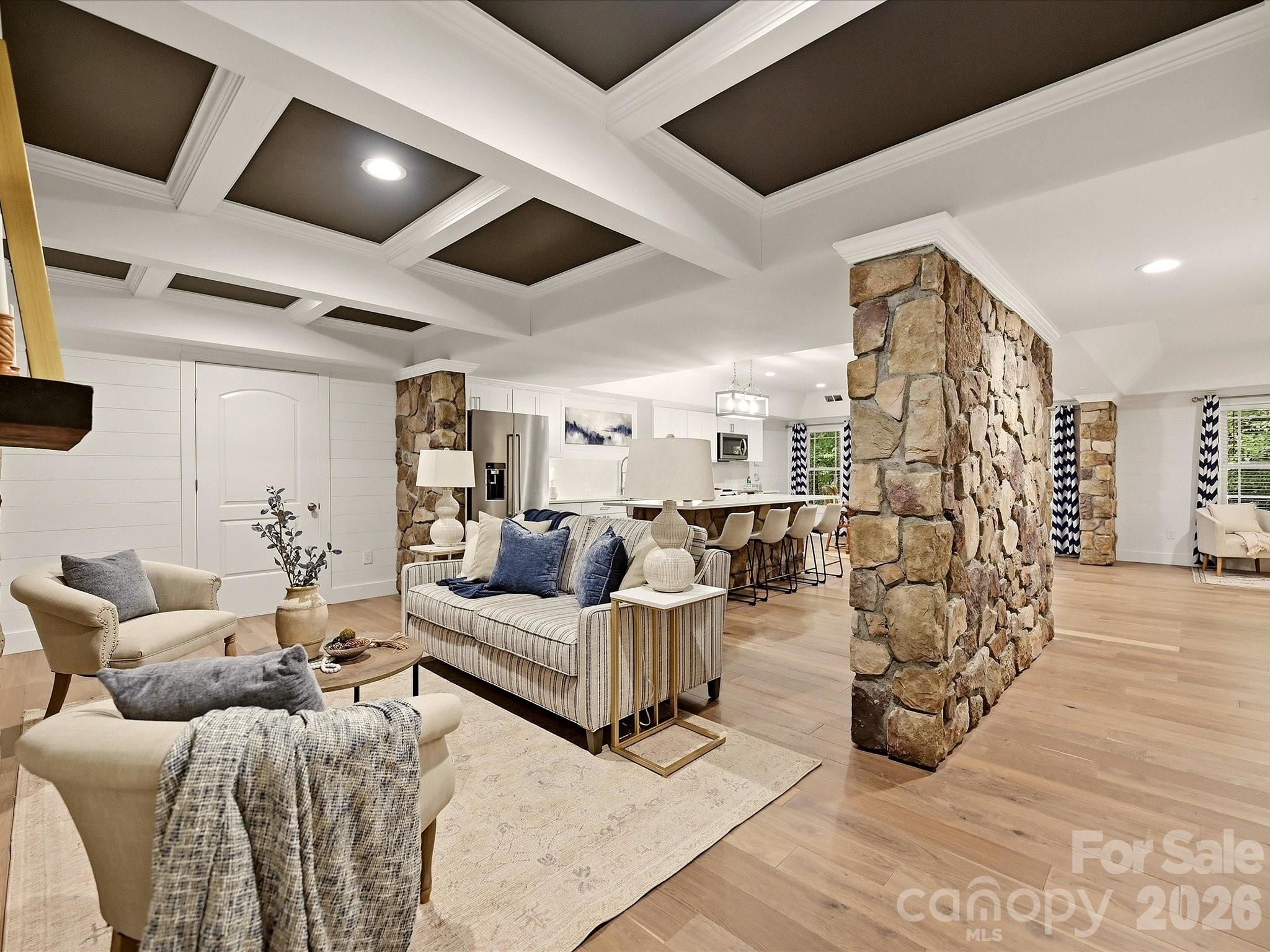 A beautifully finished basement level offers expansive open-concept living with a full kitchen, spacious lounge area, stone accents, designer ceiling details, and flexible space for entertaining or extended-stay guests. - 3167 James Plantation Drive, Denver