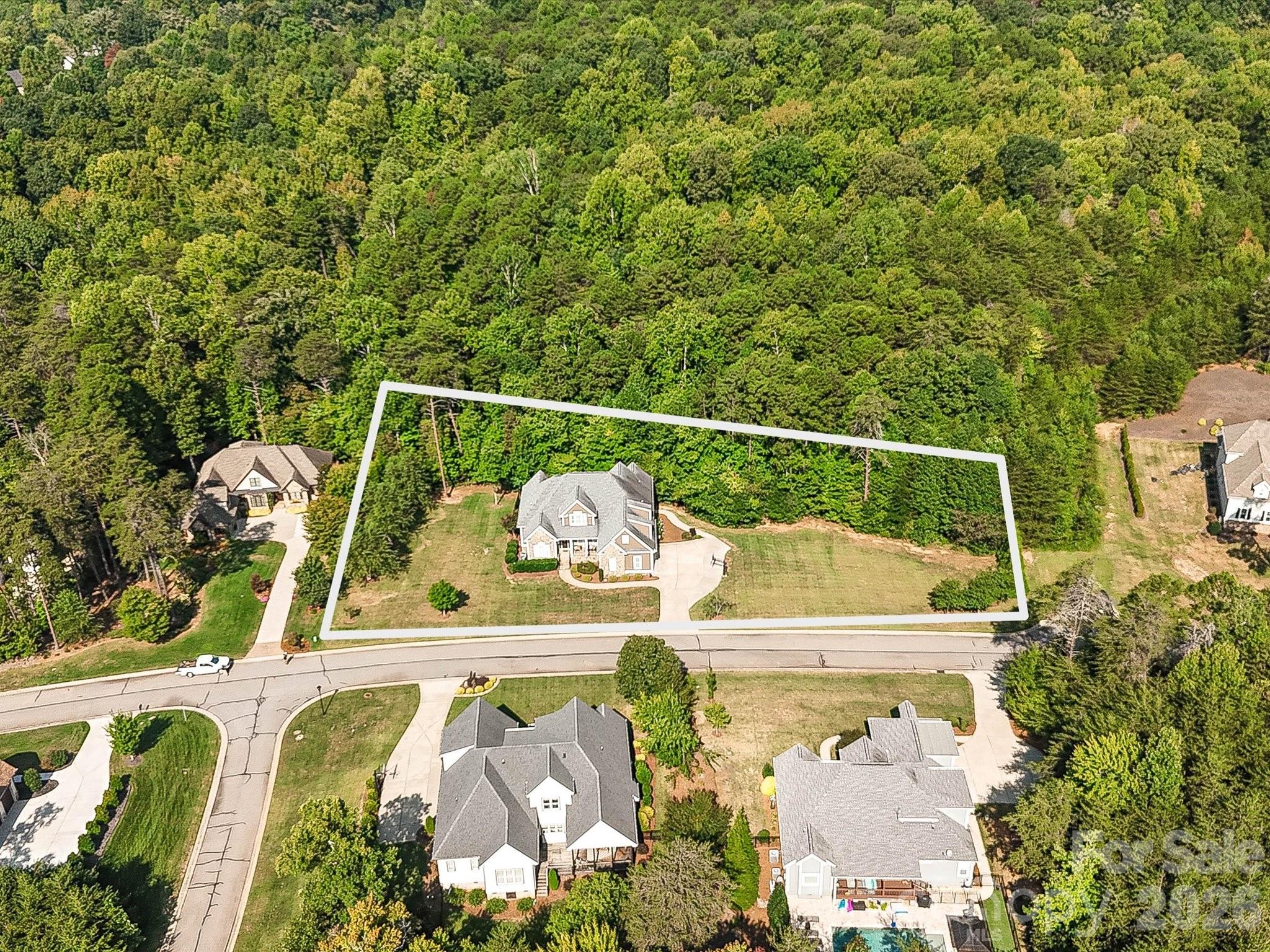 An aerial view highlights the home’s expansive lot boundaries, generous lawn space, and wooded backdrop within the surrounding residential setting. - 3167 James Plantation Drive, Denver