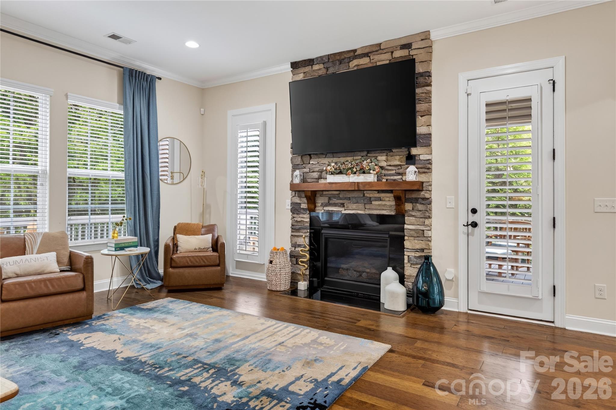 Great room with stone fireplace and hardwood floors - 1402 Smoketree Court, Waxhaw