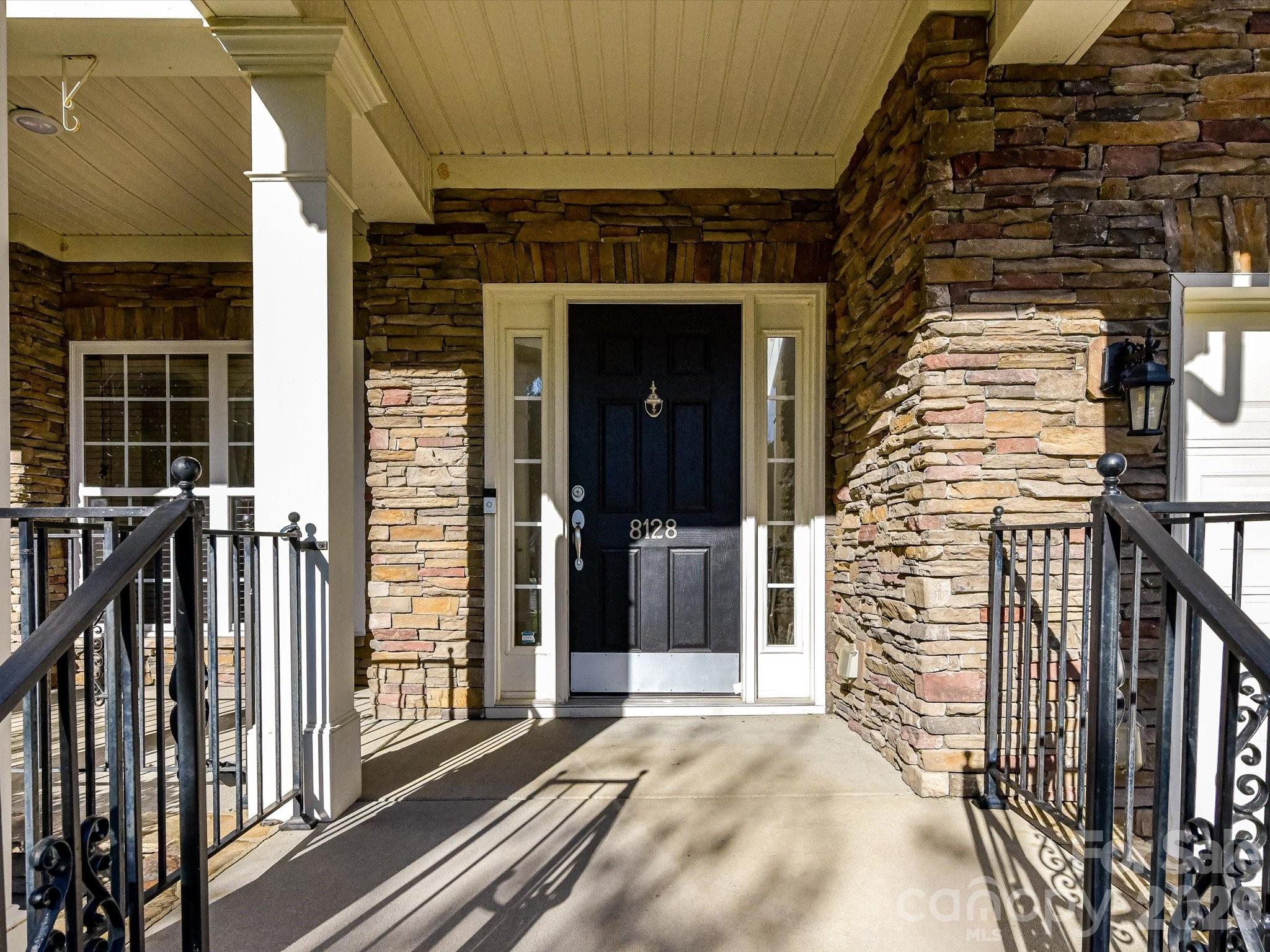 The exterior features an attractive stacked stone and low maintenance vinyl siding - 8128 Madrigal Court, Waxhaw