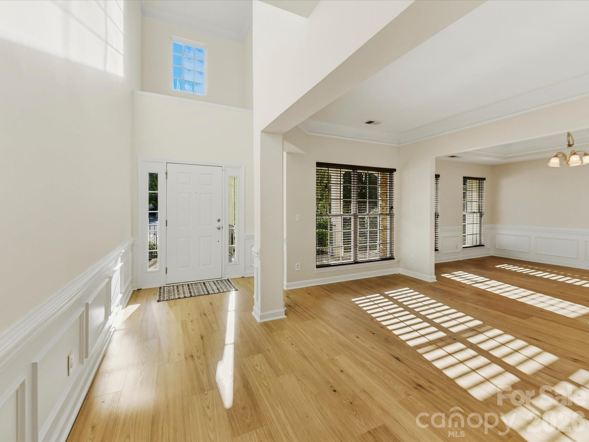 A stunning 2-story foyer features chair rail and shadowbox molding - 8128 Madrigal Court, Waxhaw