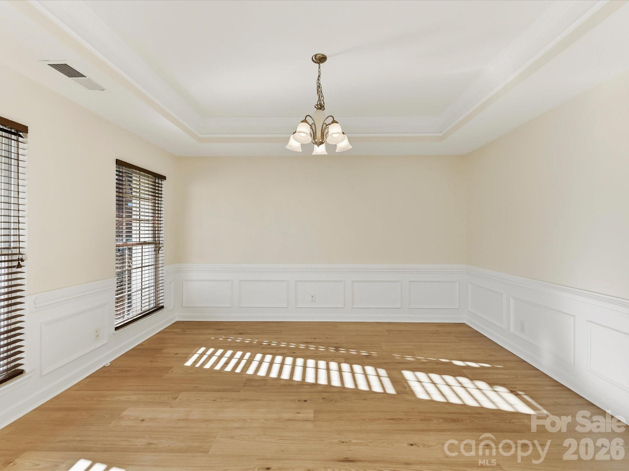 A decorative tray ceiling adorns the formal dining room - 8128 Madrigal Court, Waxhaw