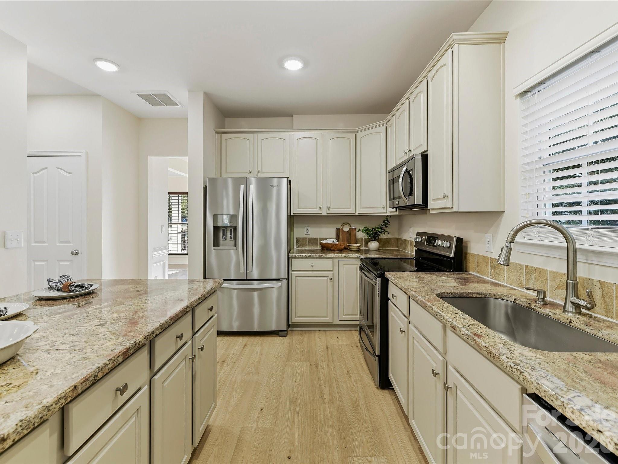 Check out theon trend colors both in flooring and on Cabinetry - 8128 Madrigal Court, Waxhaw
