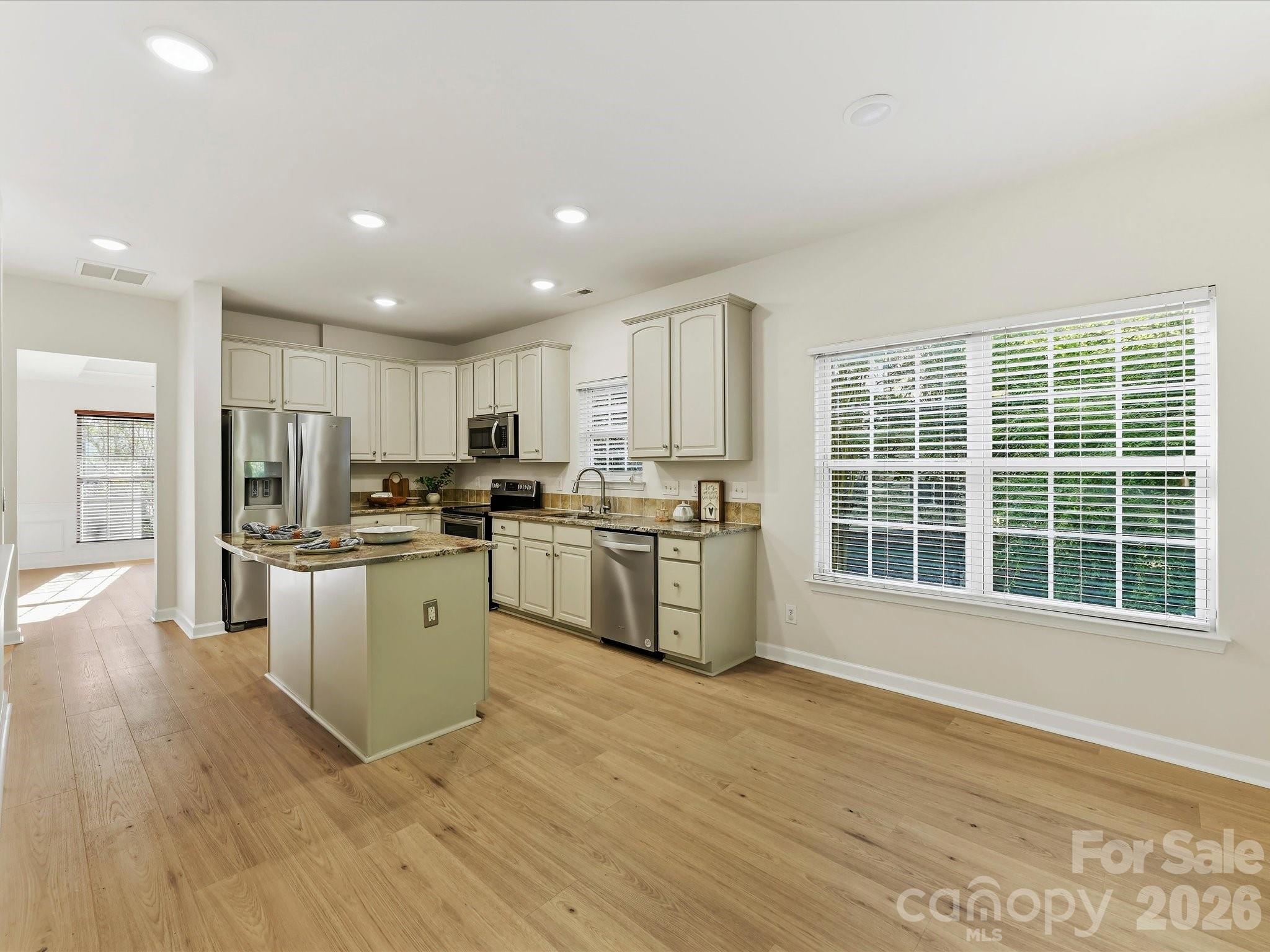 The breakfast area is surrounded with windows and patio door - 8128 Madrigal Court, Waxhaw