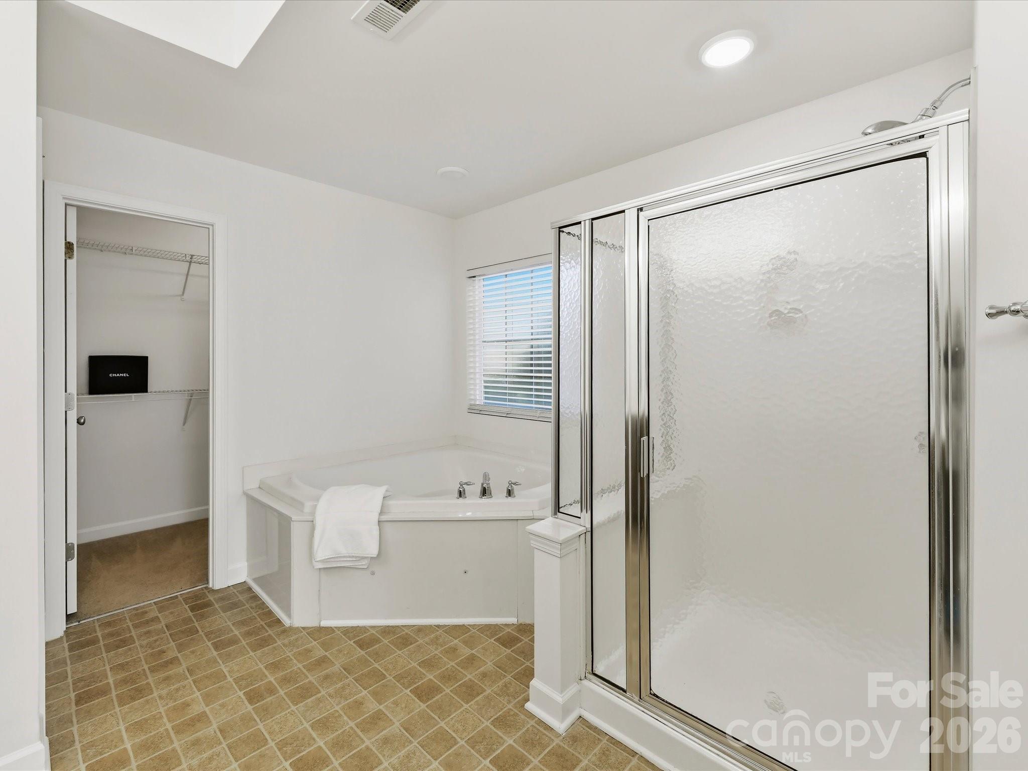 Luxury bath features a jetted tub and Step in shower - 8128 Madrigal Court, Waxhaw