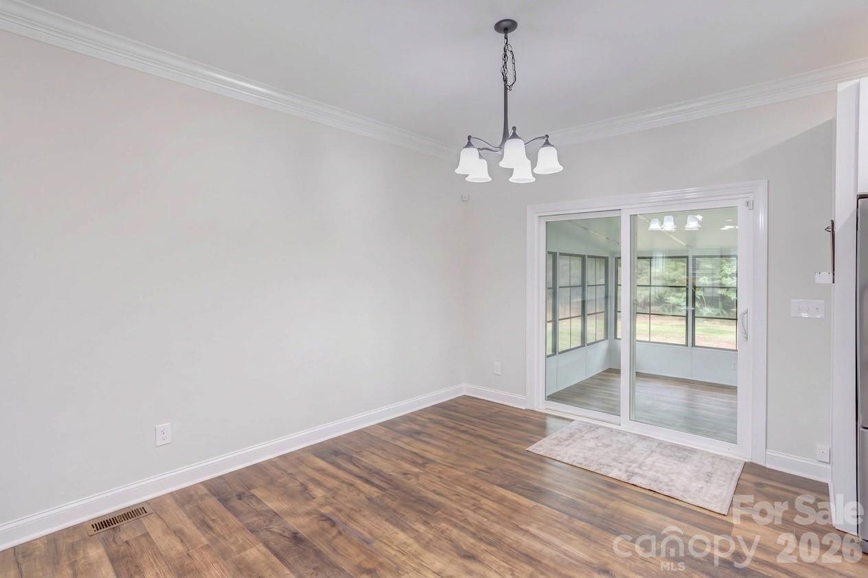 Dining area overlooks sunroom in one direction and open living room area in the other direction. - 317 Oak Brook Drive, Salisbury