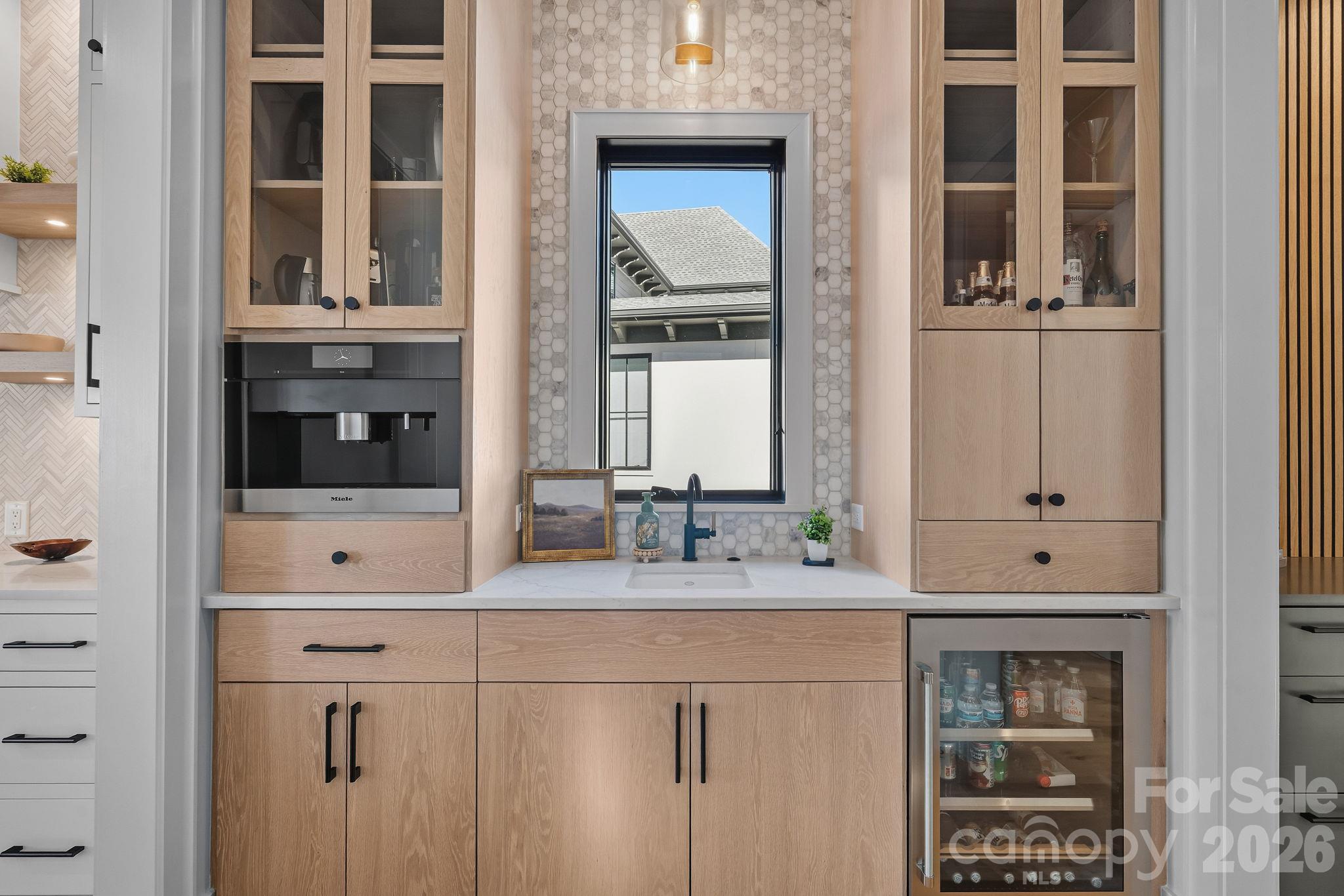 Beautifully appointed beverage station with custom cabinetry, Miele coffee system, beverage refrigeration and a convenient prep sink. - 17811 Largo Place, Cornelius