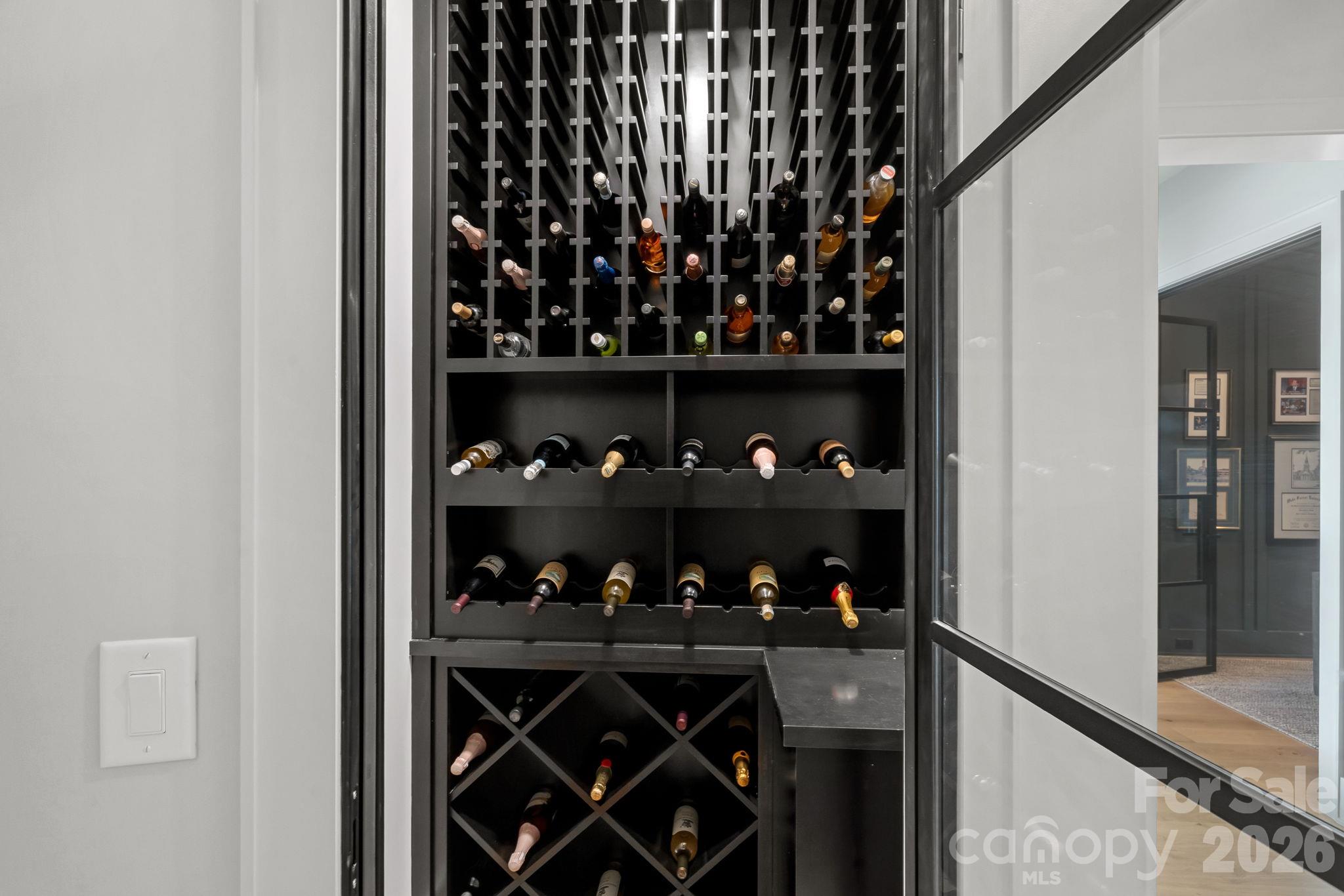 A striking glass-enclosed wine display brings a bespoke, gallery-like element to the home. - 17811 Largo Place, Cornelius
