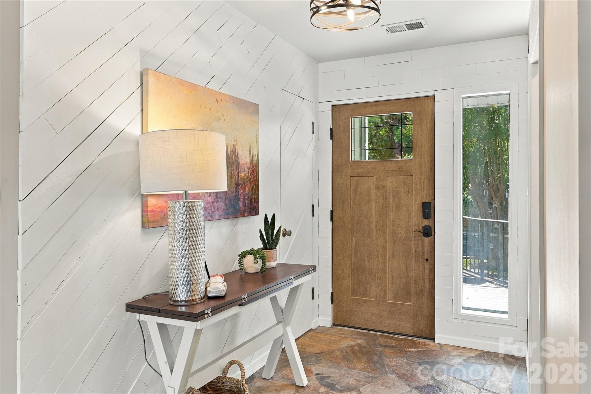 Foyer with stone flooring and painted wood accent wall - 9071 Tulagi Court, Tega Cay