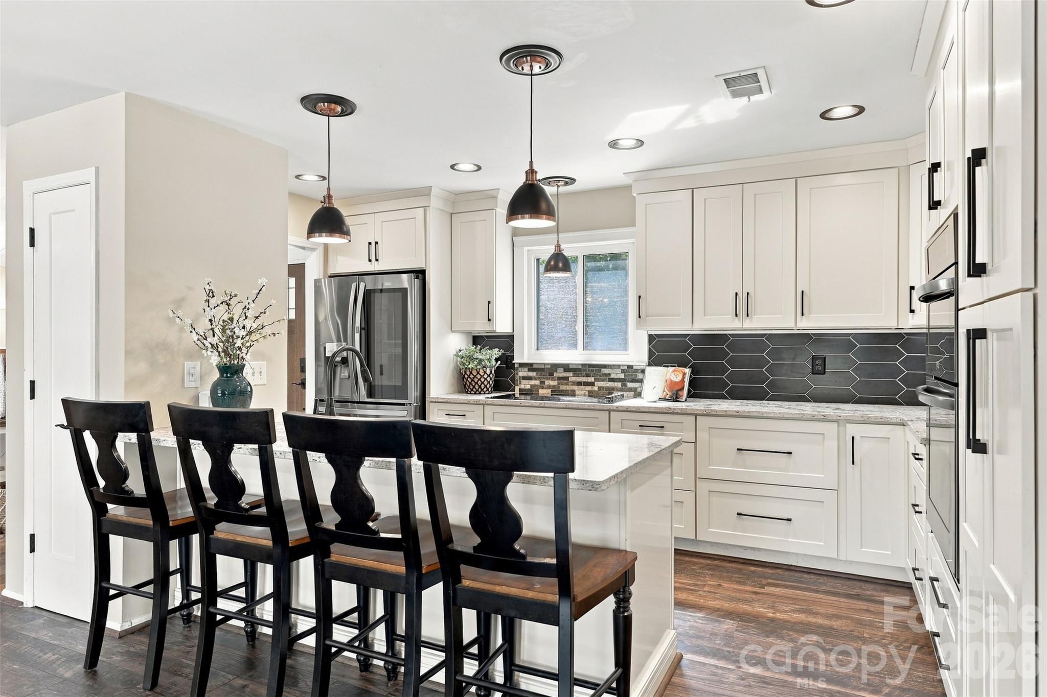 Updated kitchen with breakfast bar, granite countertops, custom cabinetry, stainless steel appliances, tile backsplash and pantry - 9071 Tulagi Court, Tega Cay
