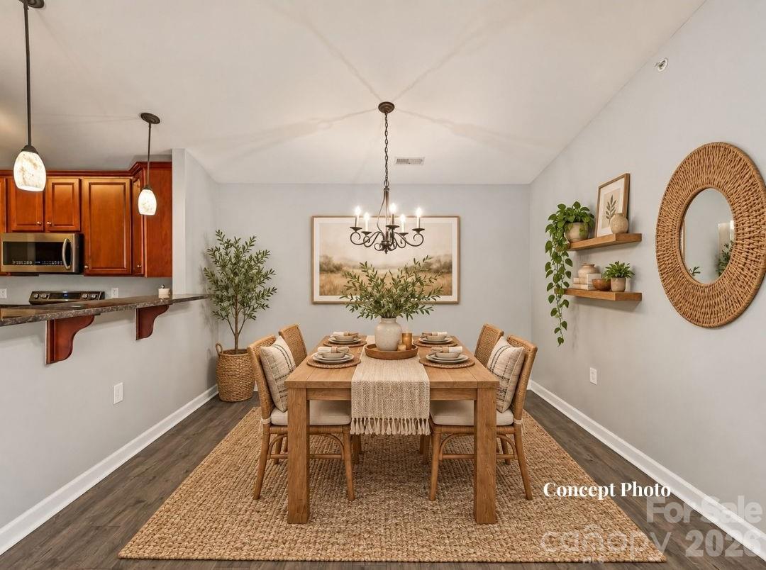 Virtually staged Spacious dining area featuring LVP flooring, a vaulted ceiling, decorative chandelier, and a convenient breakfast bar connecting seamlessly to the kitchen. - 9031 Mcdowell Creek Court, Cornelius