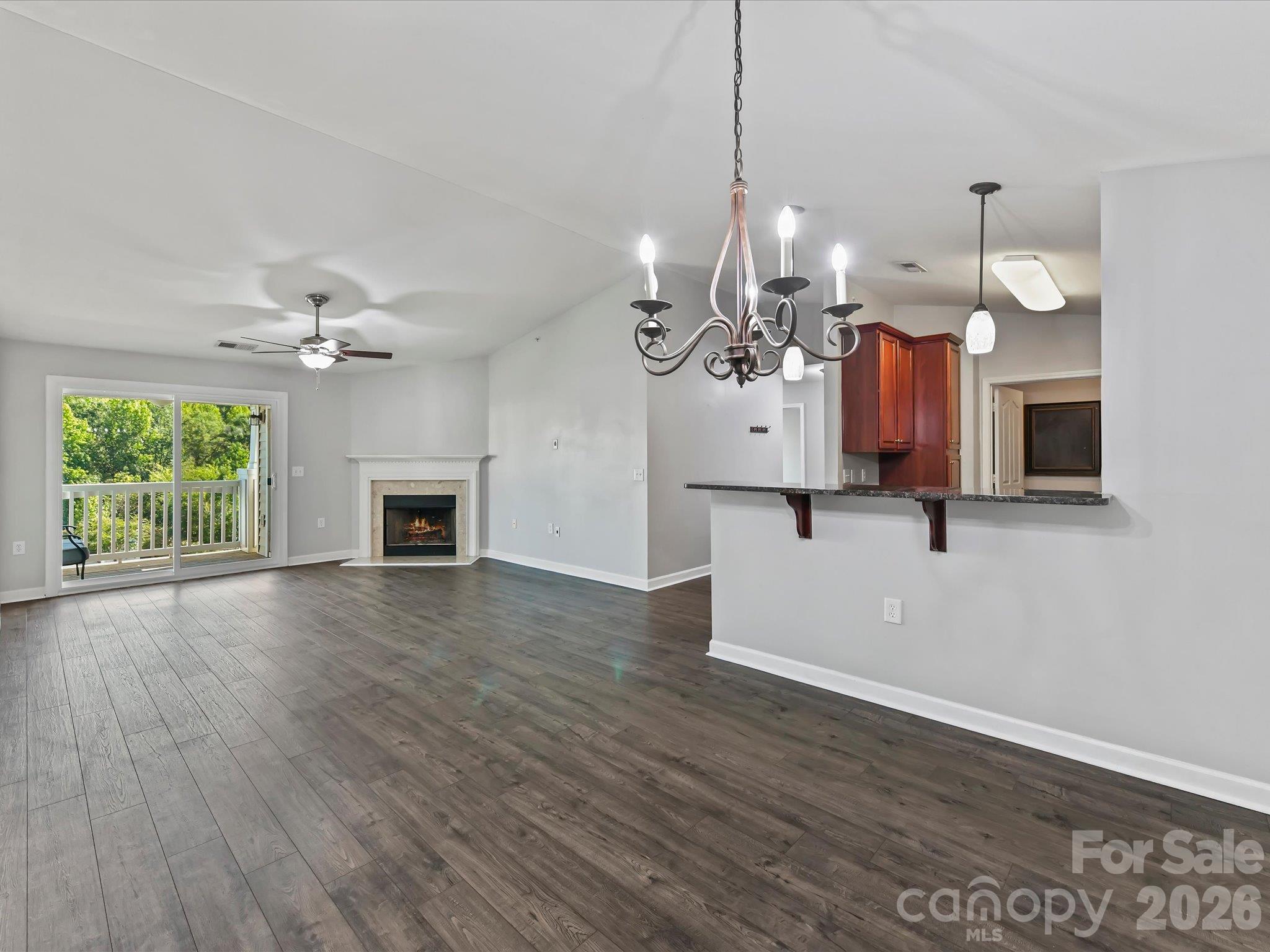 Spacious dining area featuring LVP flooring, a vaulted ceiling, statement chandelier, and an open connection to the kitchen and family room for easy entertaining. - 9031 Mcdowell Creek Court, Cornelius