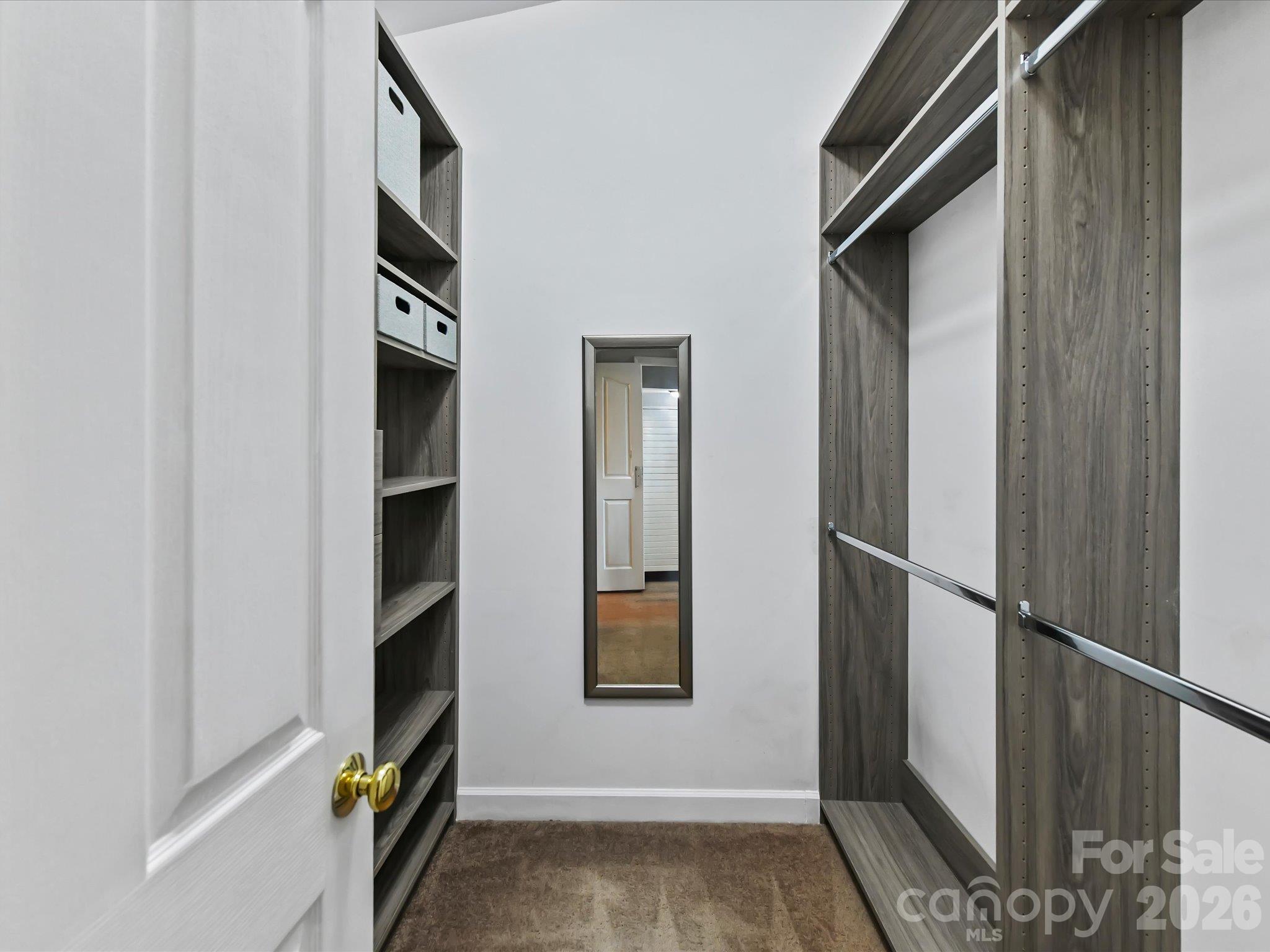 Spacious primary walk-in closet featuring a custom organization system with built-in shelving, multiple hanging areas, and generous storage space. - 9031 Mcdowell Creek Court, Cornelius