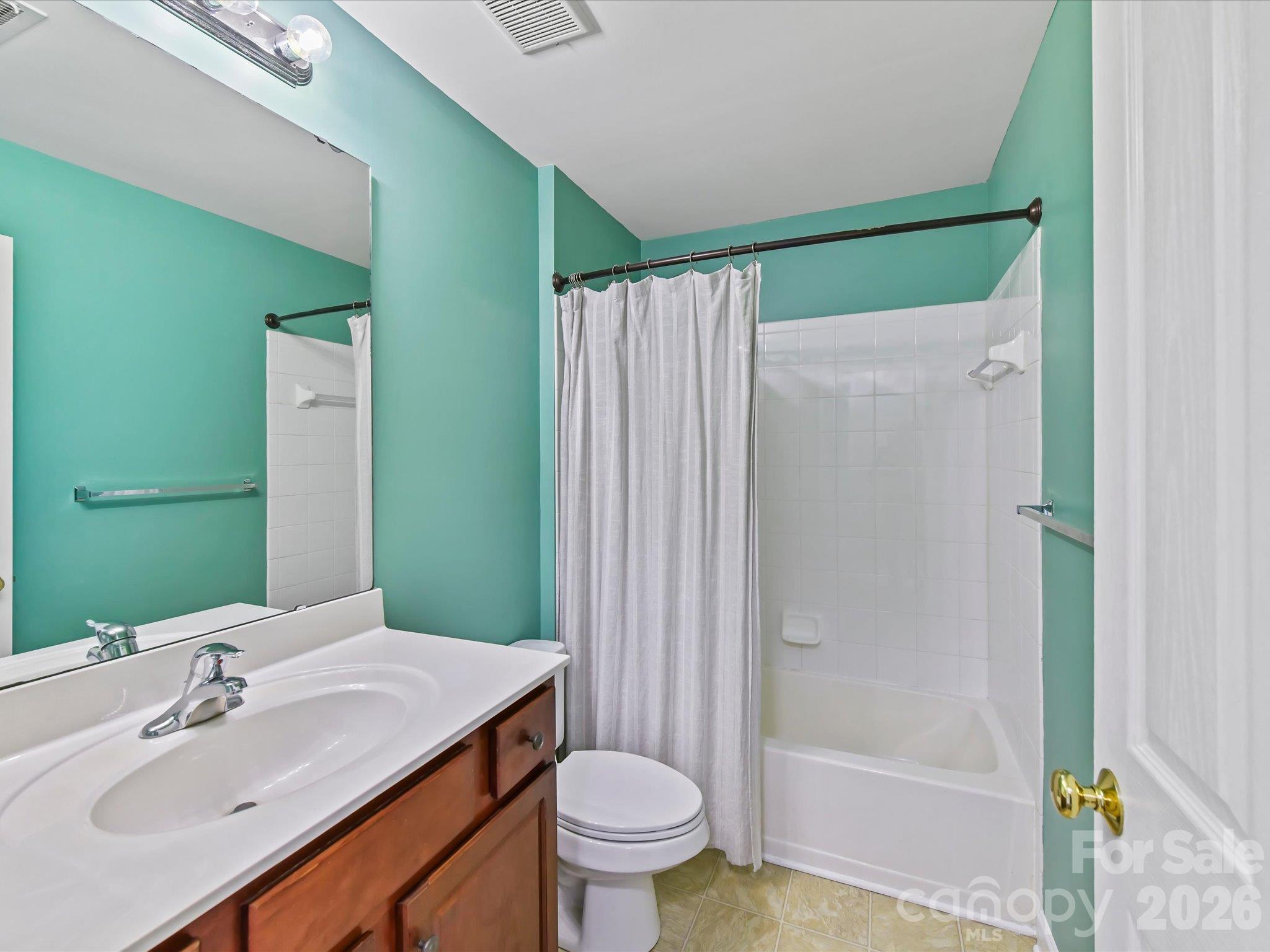 Full bath featuring a spacious vanity, large mirror, tub/shower combination with tile surround, and a bright, functional layout. - 9031 Mcdowell Creek Court, Cornelius