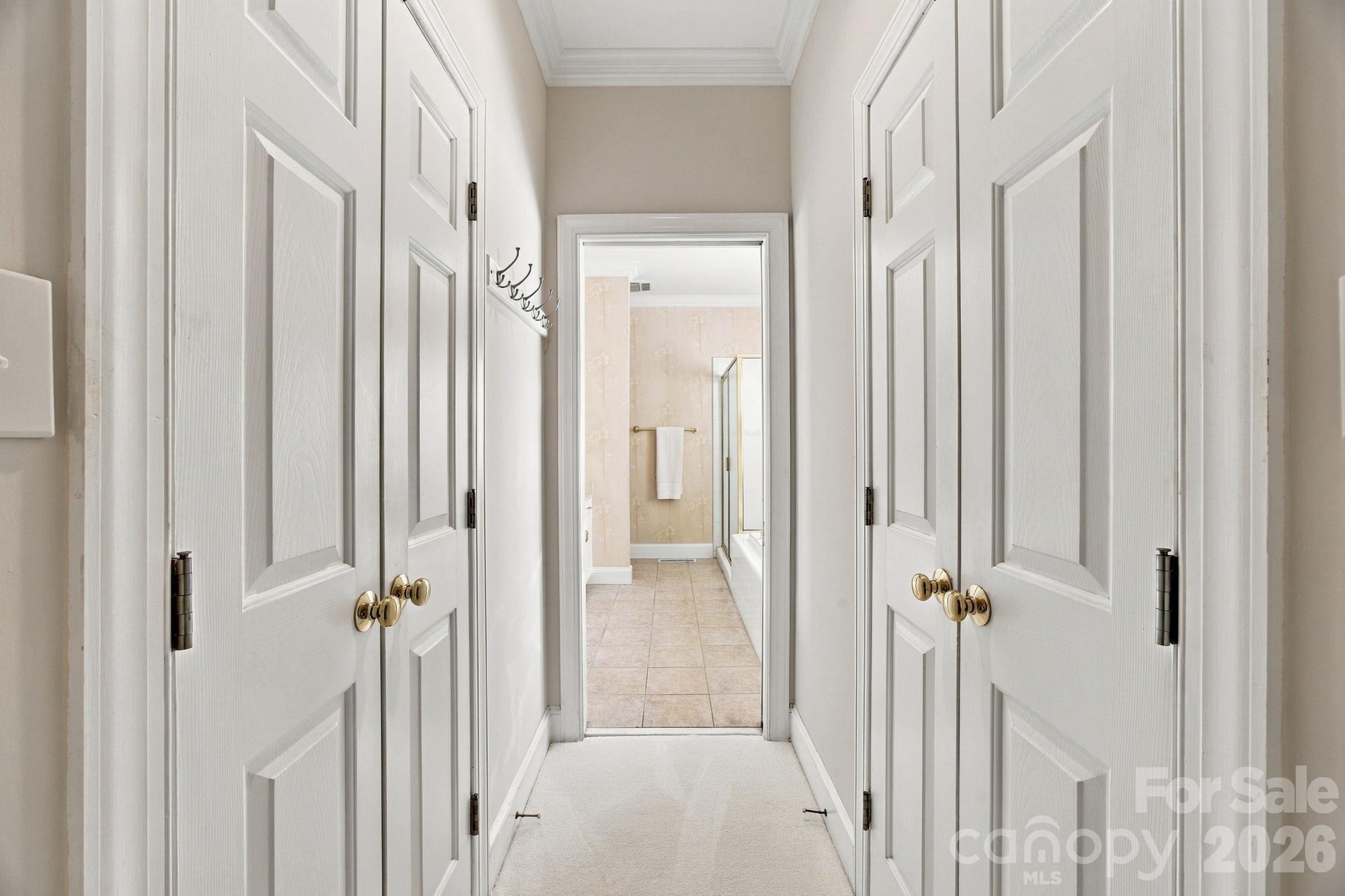 Primary Bedroom leading into the Primary Bath with double walk-in closets along the way - 10417 Newberry Park Lane, Charlotte