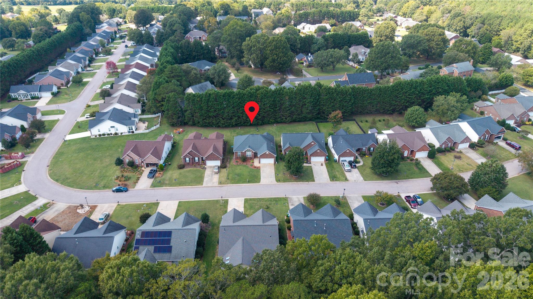 Aerial view is from the front view of the property and highlighting the property's prime location, featuring a lush tree-lined backdrop, established neighborhood street, and a low-maintenance lot layout. - 1011 Overhill Road, Salisbury