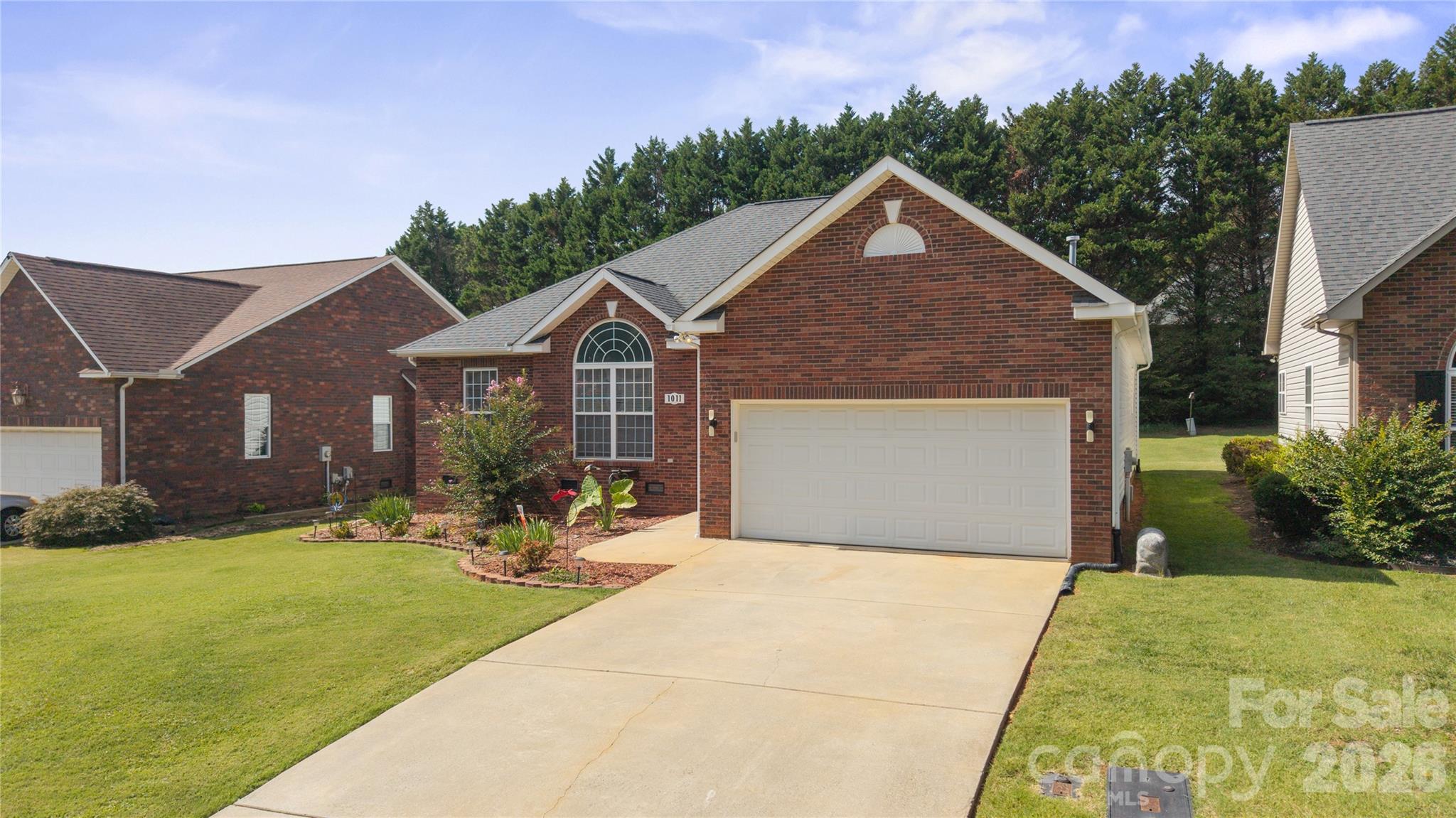Enjoy this beautiful partially brick ranch home in this quaint Willows of Woodfield neighborhood with attached two-car garage, manicured front lawn, arched windows, and a wide concrete driveway. - 1011 Overhill Road, Salisbury