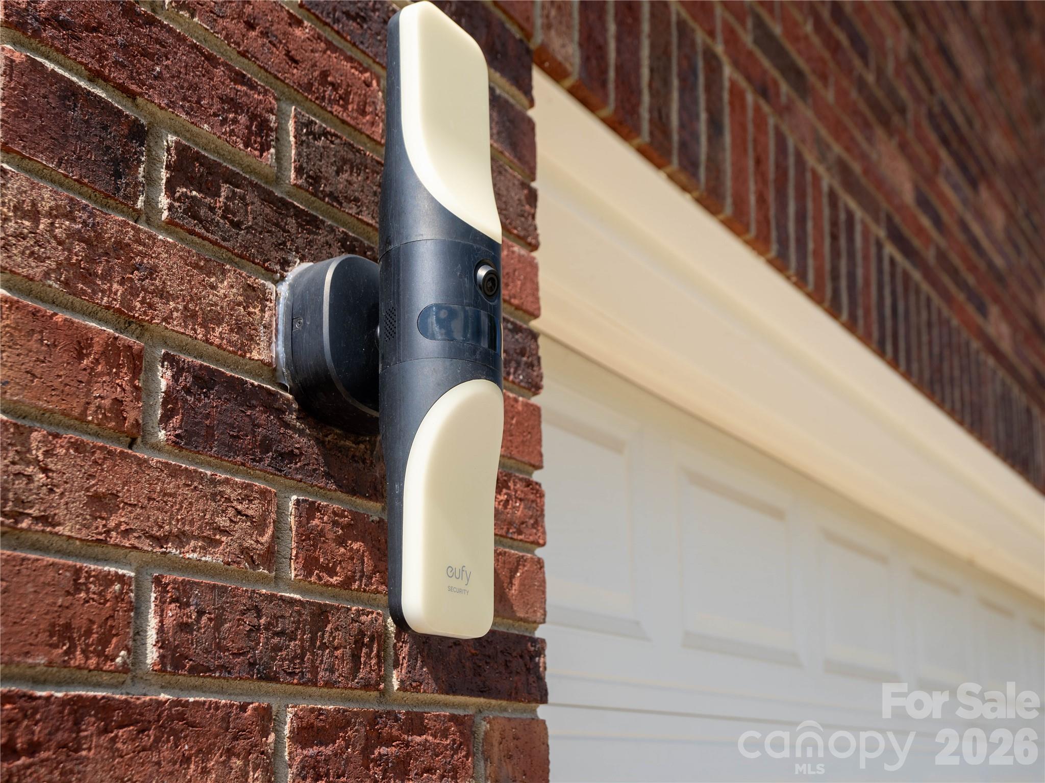 Two Eufy floodlight cameras on either side of the garage with color changing light effects - 1011 Overhill Road, Salisbury