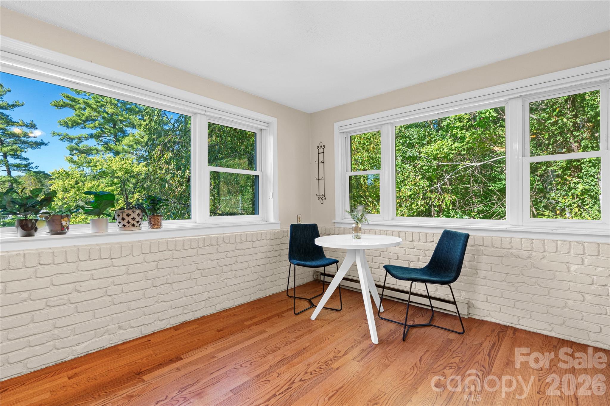Bright eat-in kitchen featuring generous windows, ample natural light, and a comfortable space for casual dining. - 18 Northwood Road, Asheville