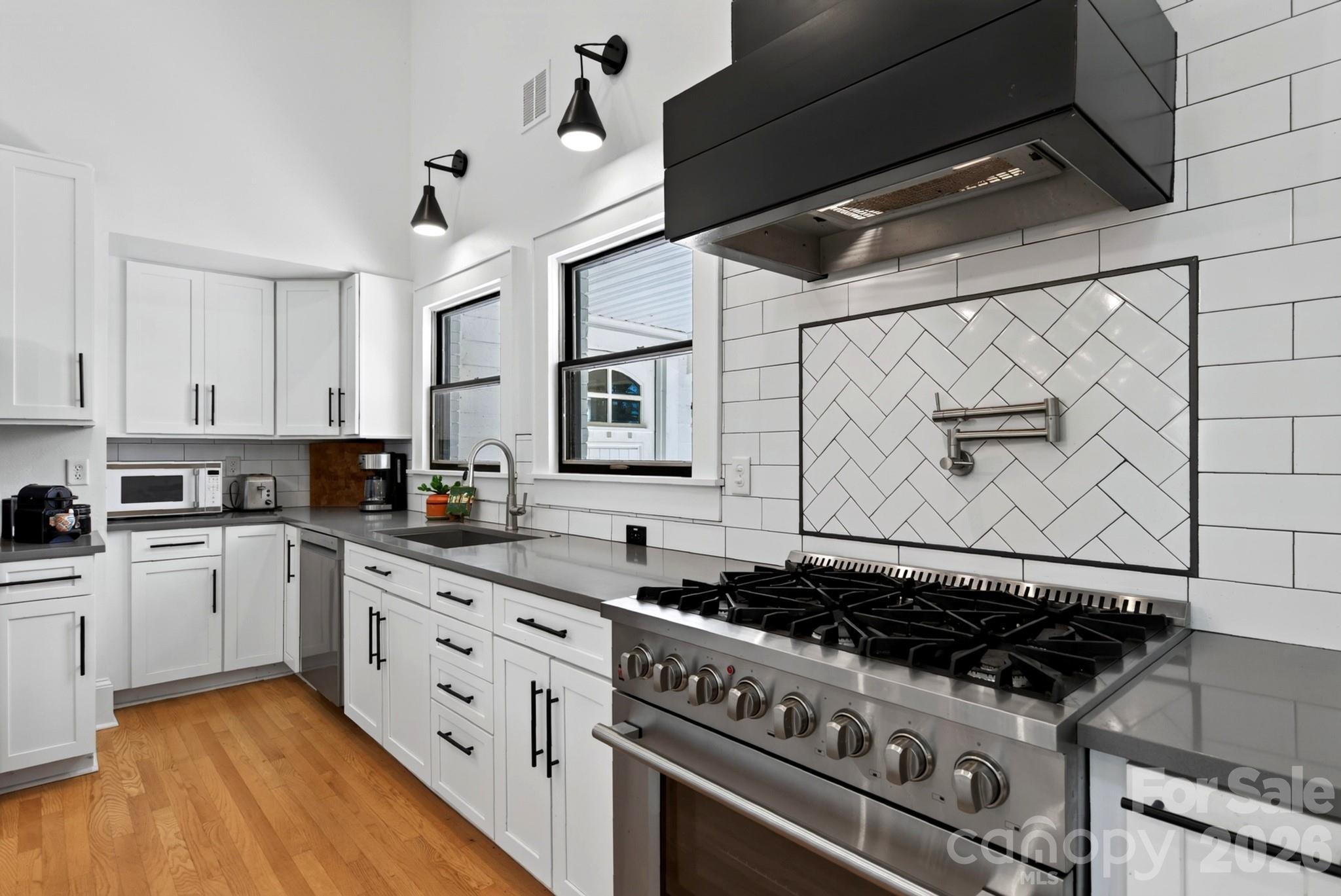 6 burner gas stove with custom hood vent, pot filler and subway tile backsplash - 5 Inglewood Road, Asheville
